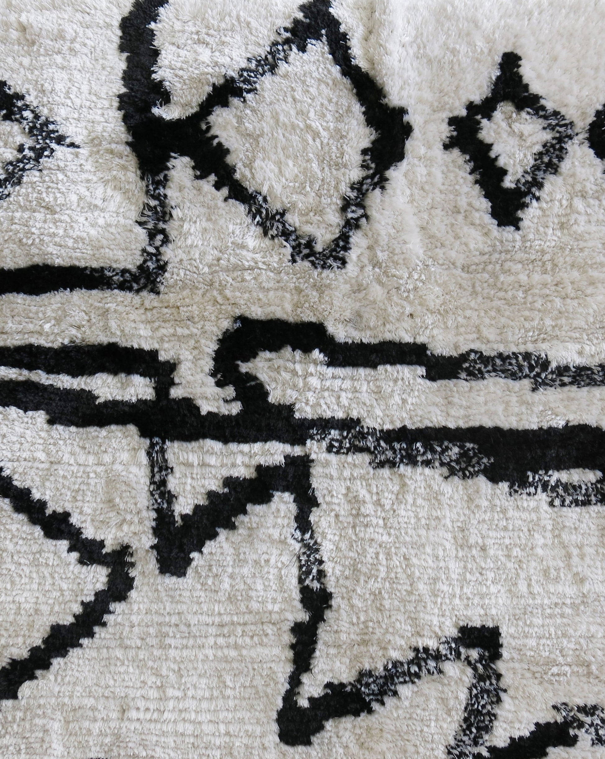 An Akimbo Hand Knotted Rug Black And White with graphic geometric designs on it