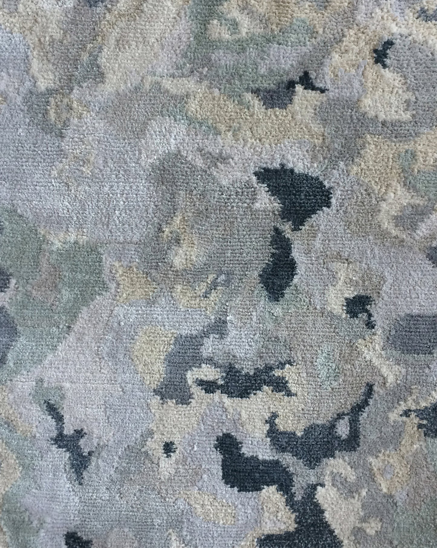 A close up image of the Alabaster Hand Knotted Rug Light with blue undertones and veined patterns