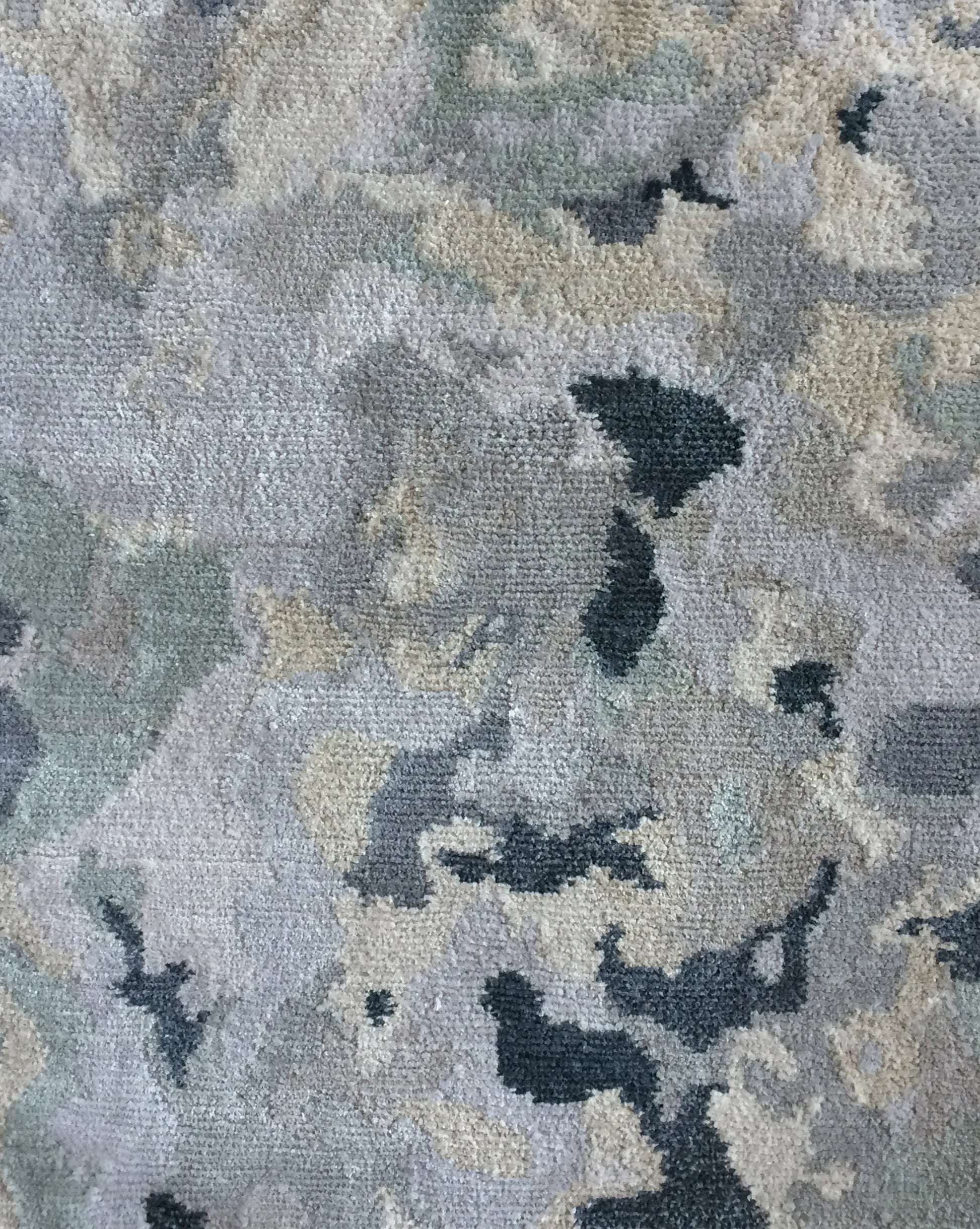 A close up image of the Alabaster Hand Knotted Rug Light with blue undertones and veined patterns