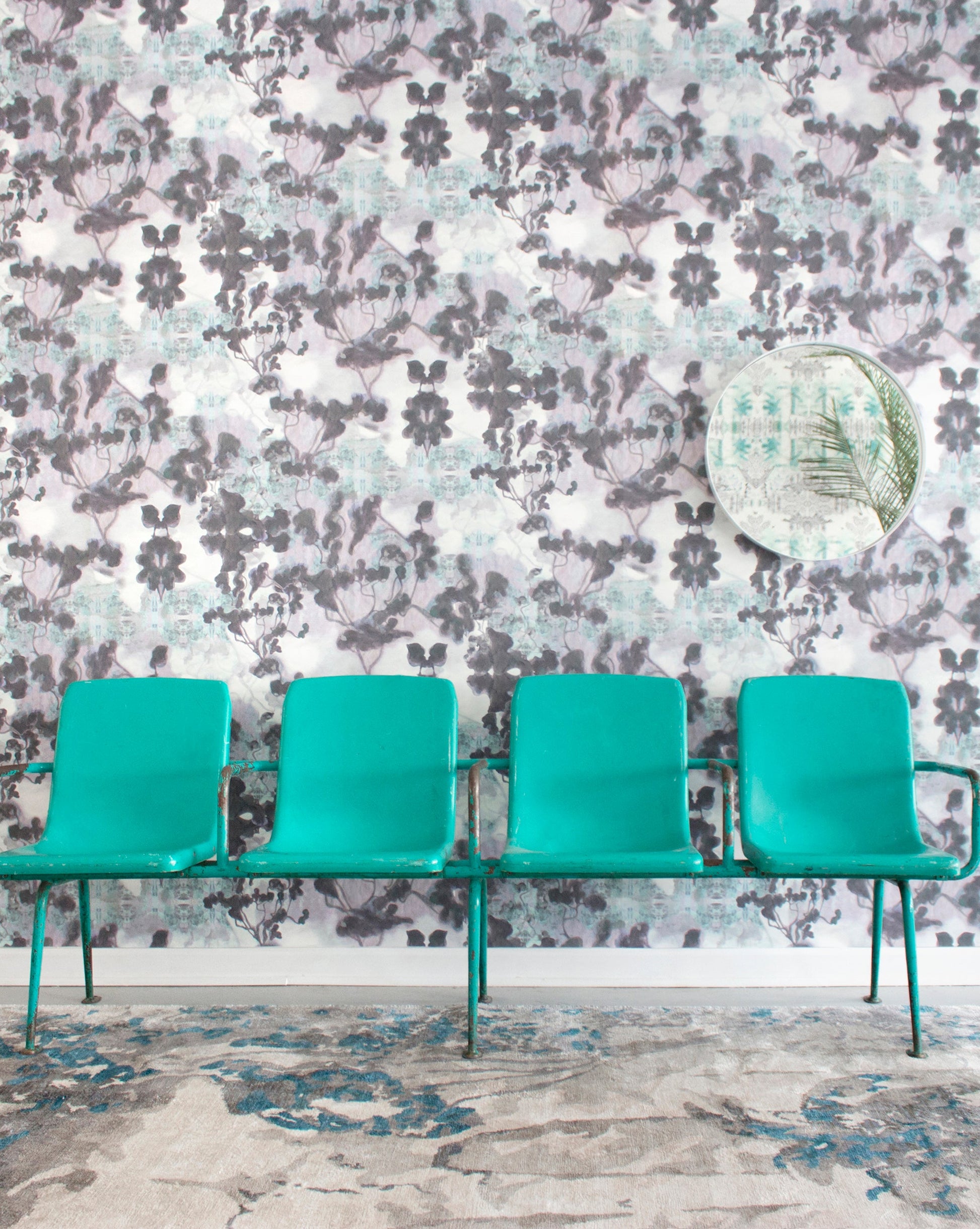 A row of green chairs in front of a Cabrillo Hand Knotted Rug  Stone wallpapered wall