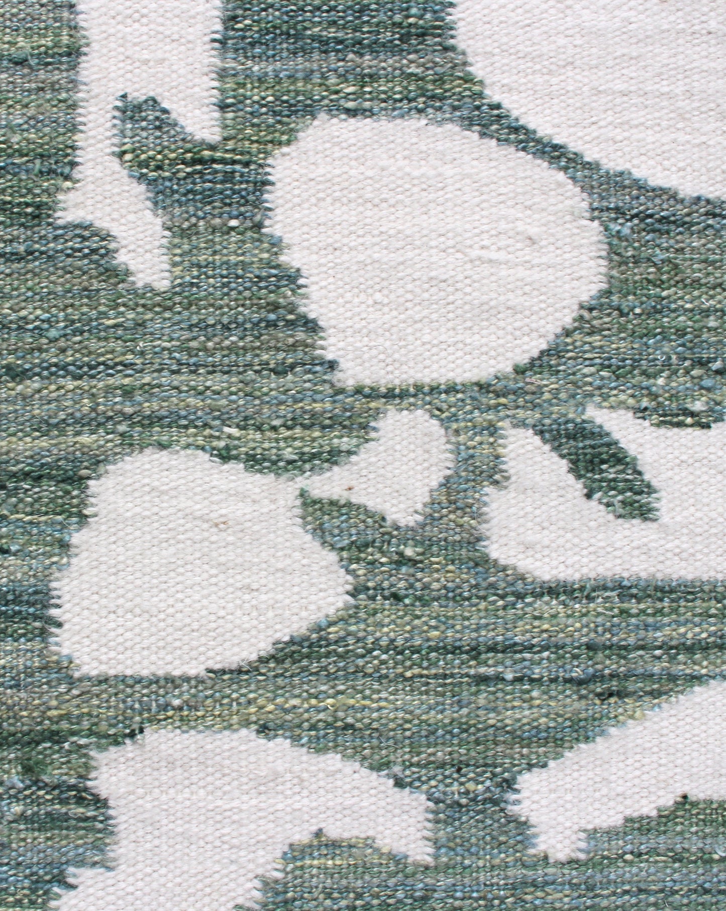 A close up of a green and white Banda Flatweave Rug Chloros