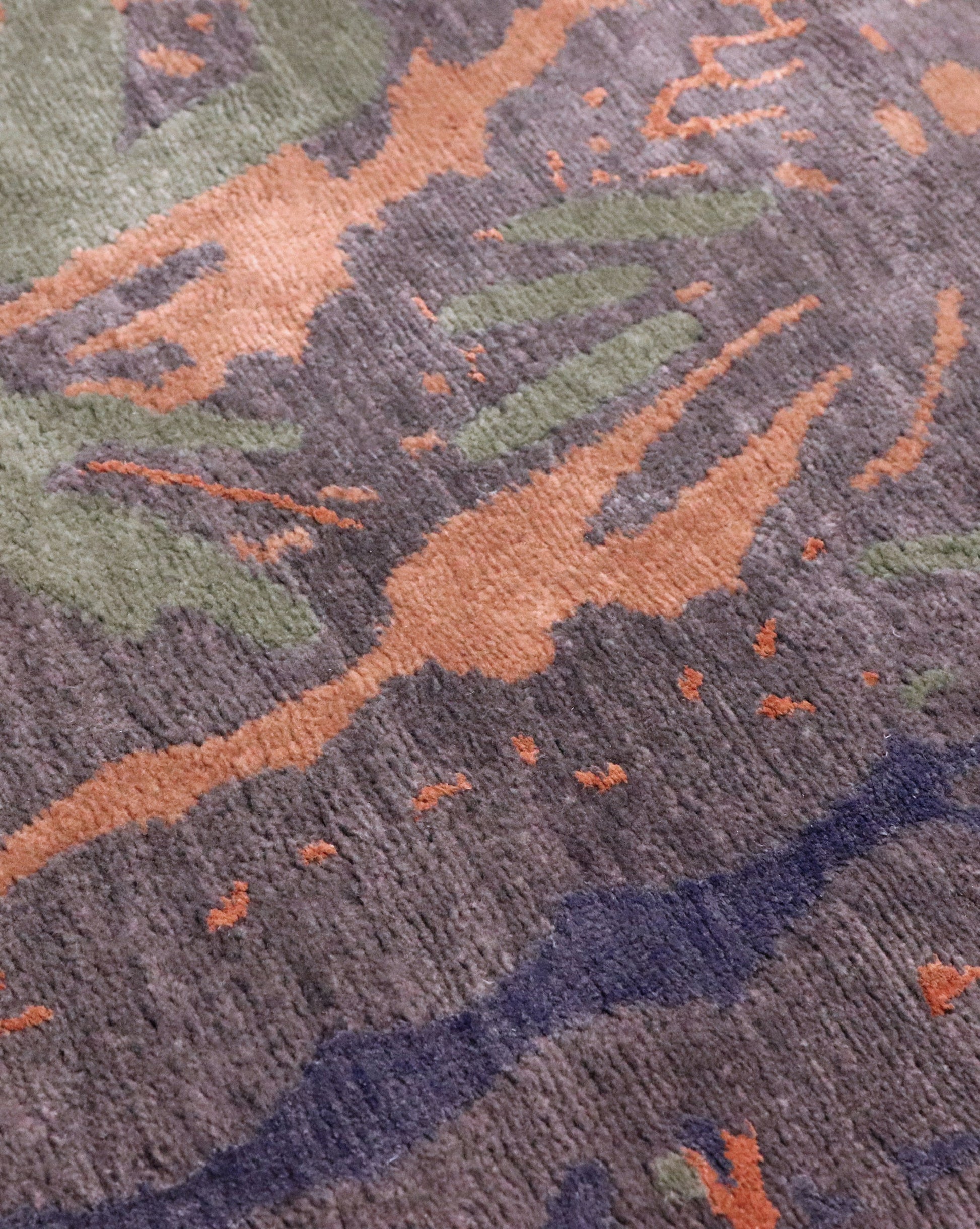 A close up of a rug from the Adriatico Hand Knotted Rug Tesoro Collection with an Adriadico design featuring vibrant orange, green, and blue colors
