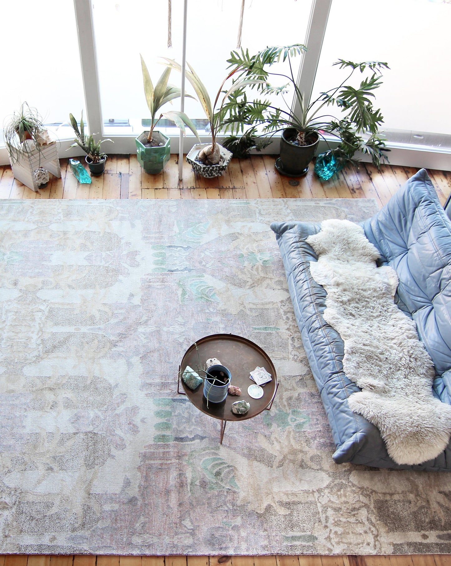 A luxury handmade Clairmont Hand Knotted Rug Stucco from the Presidio Collection by Eskayel in a living room with plants on it