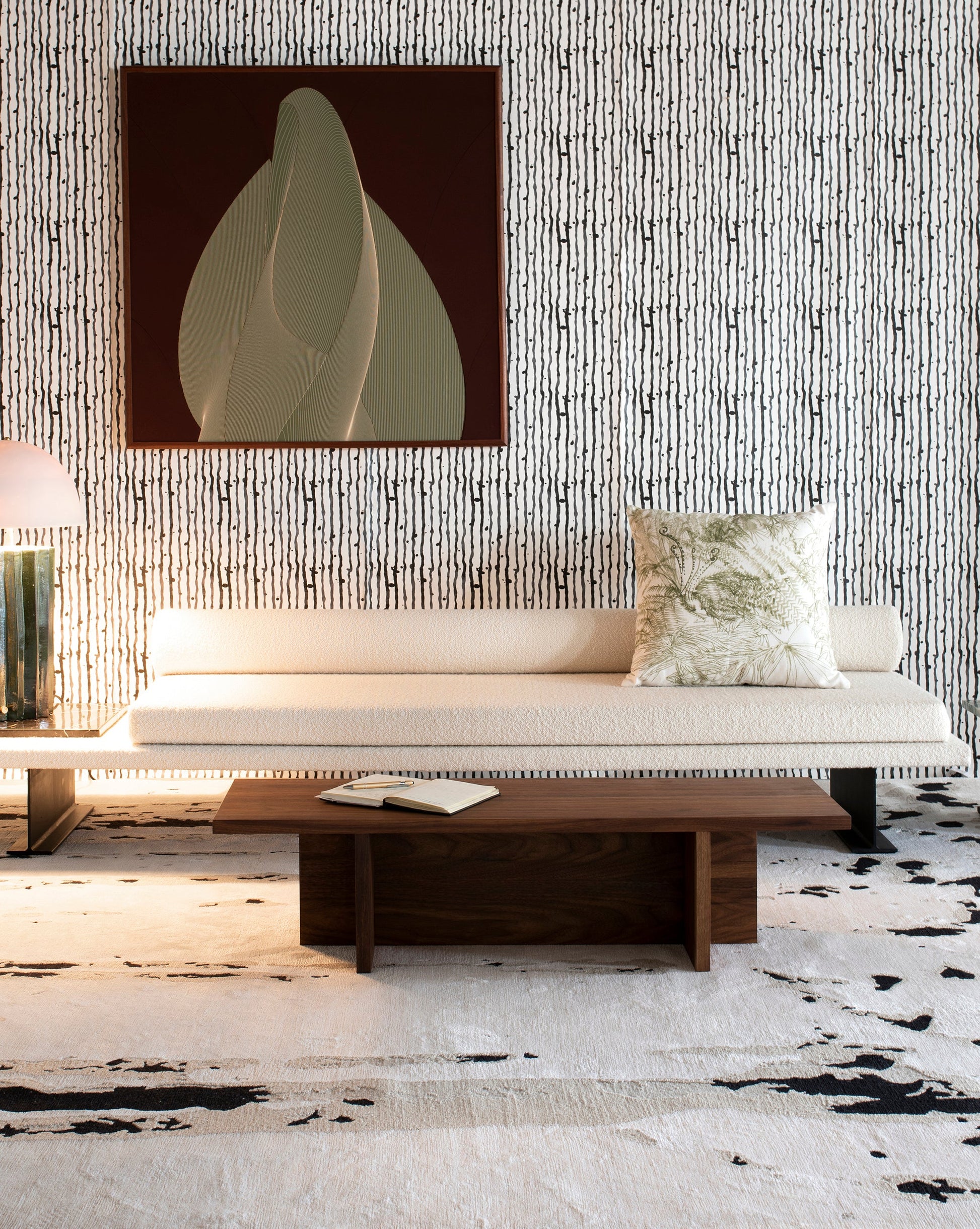 A couch in a living room with a painting on the wall and a Linea Hand Knotted Rug Black And Beige