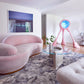 A pink couch in a living room with a Palmeti Hand Knotted Rug Notte design