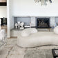 A living room with a white couch and a fireplace, featuring a Portico Hand Knotted Rug Sol