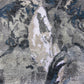 A close up image of Palmeti Hand Knotted Rug Notte featuring shades of grey and blue