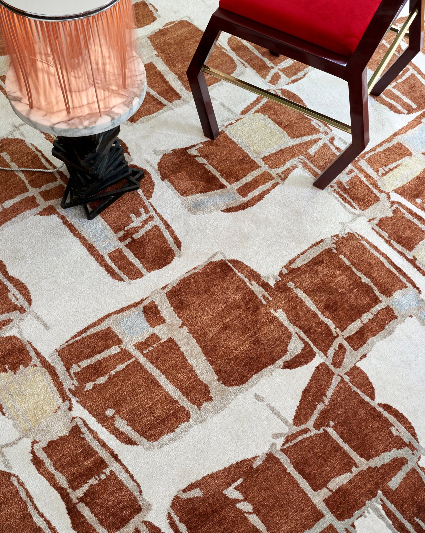 A room with a brown rug and a Quotidiana Hand Knotted Rug Burnt Sienna