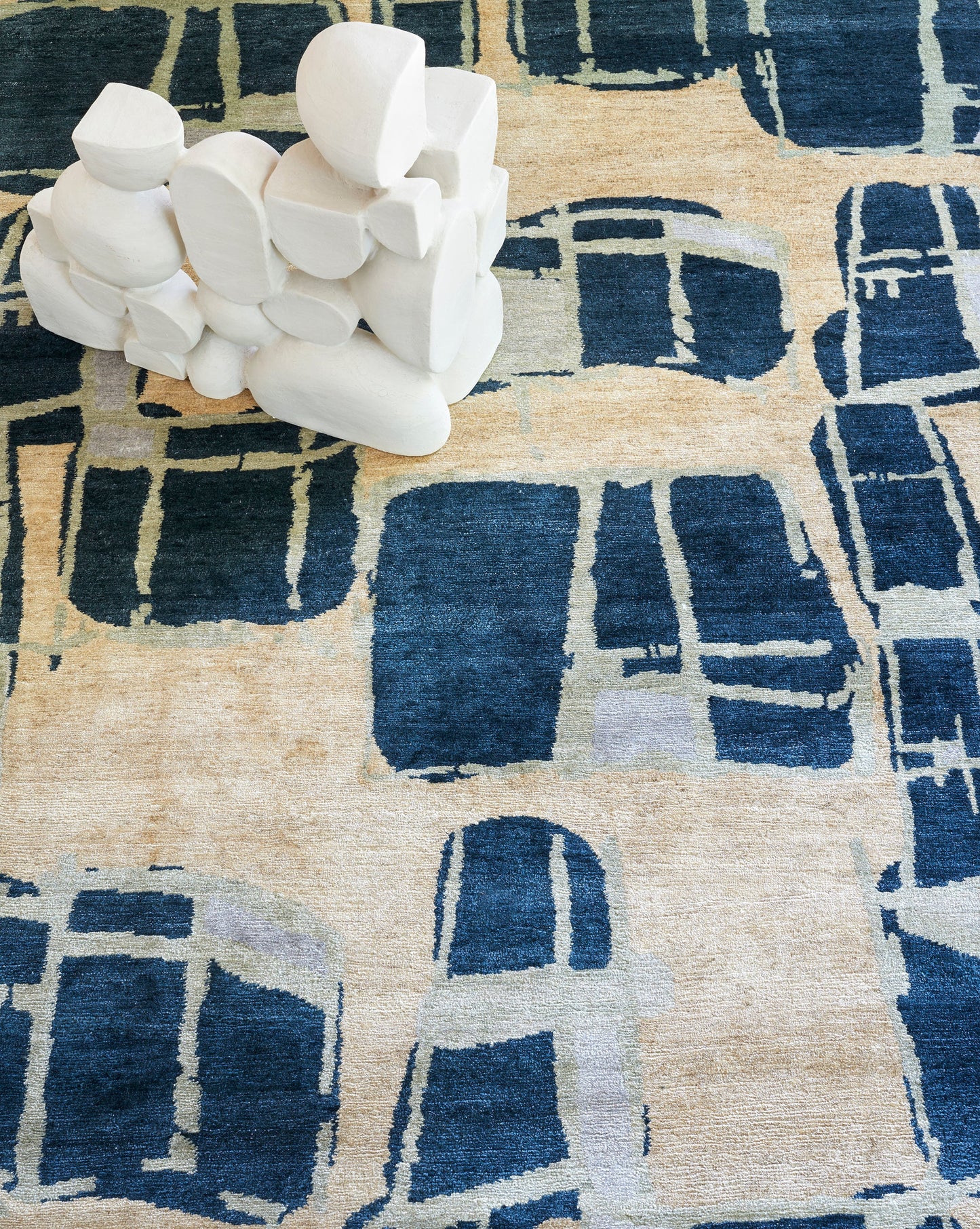 A Quotidiana Hand Knotted Rug Corinth design with a bunch of rocks on it
