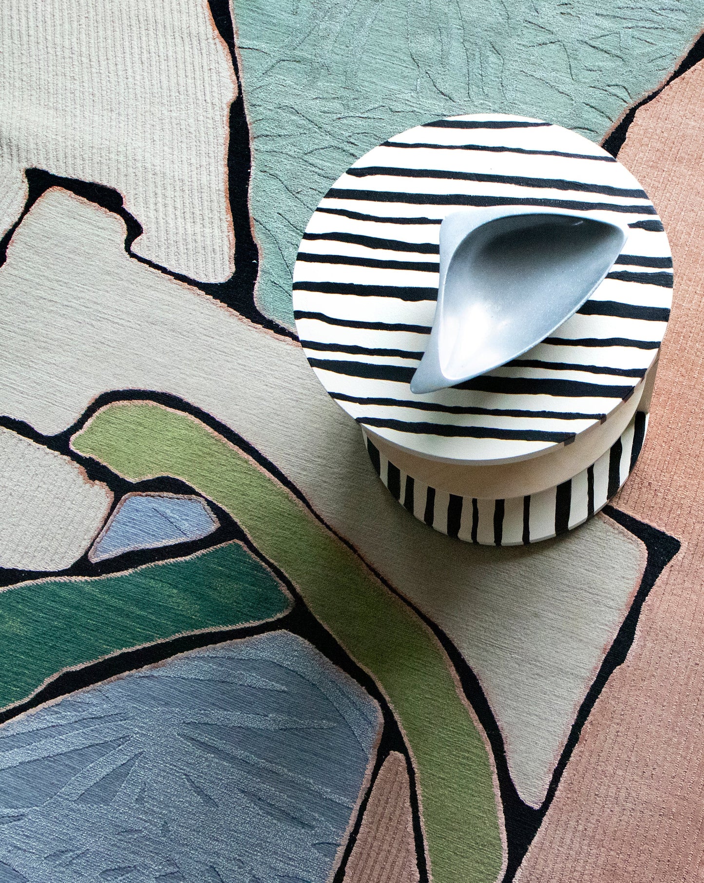 A Sky Arc Hand Knotted Rug with a bowl on top of it