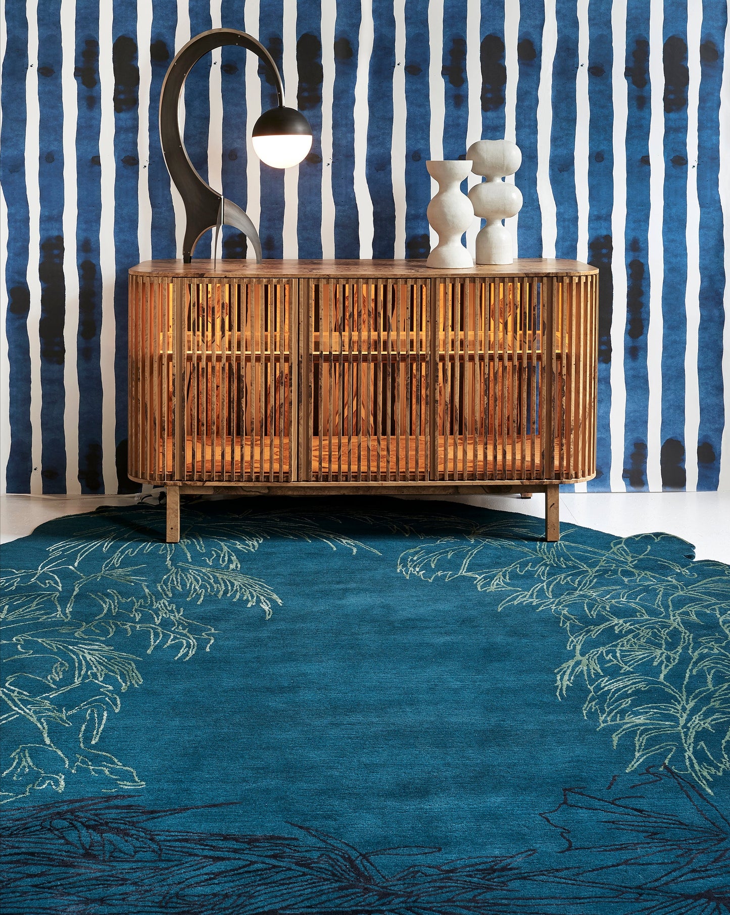 A Through The Grove Hand Knotted Rug Azure from the Salentu Collection in front of a blue wall