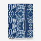 A blue and white Akimbo Wallpaper Indigo Ikat print with a graphic geometric pattern on wallpaper