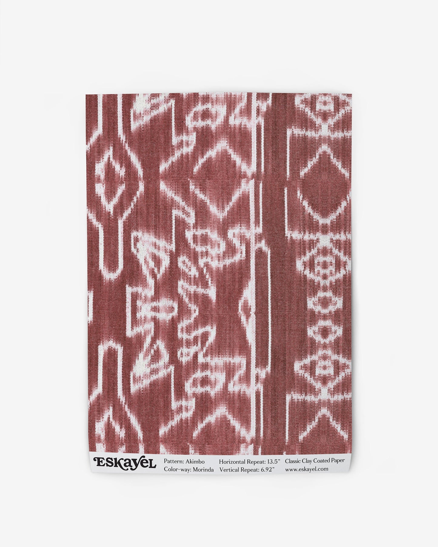 A red and white Akimbo Wallpaper with a Morinda Ikat pattern on a piece of cloth