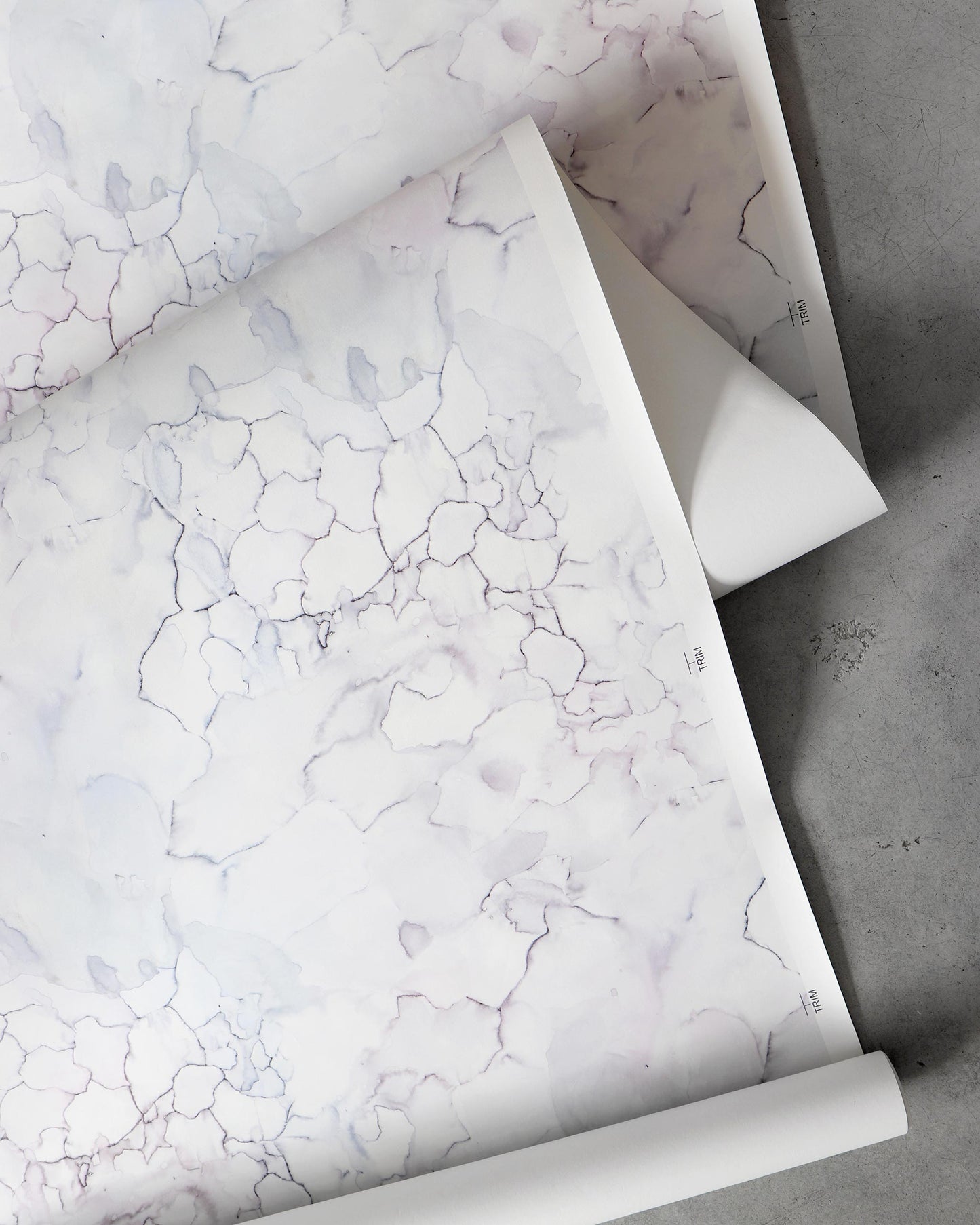 A roll of Aquarelle Wallpaper Ice with a marble pattern on it