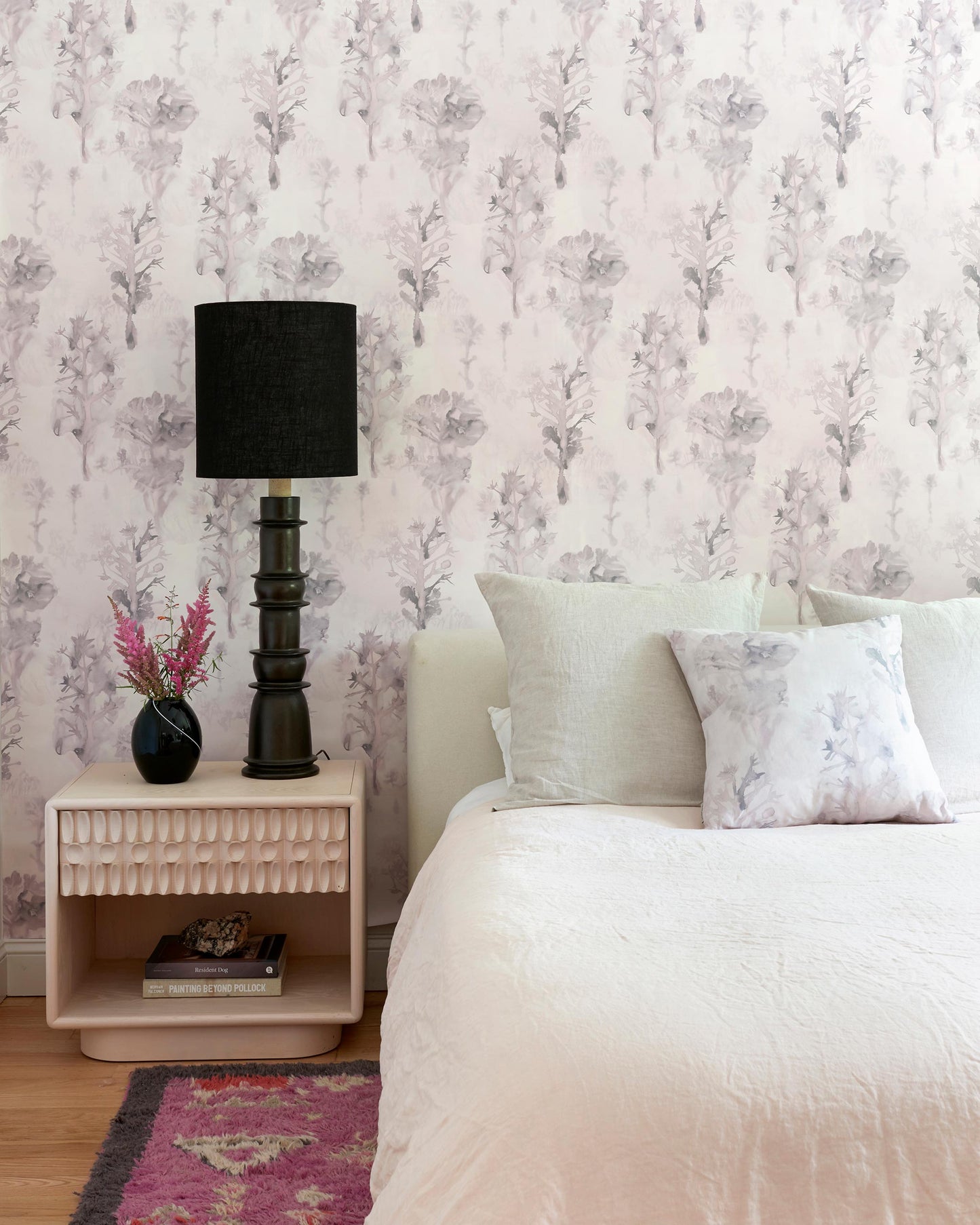 A bed in a room with a bedside table and Aionas Wallpaper Alba