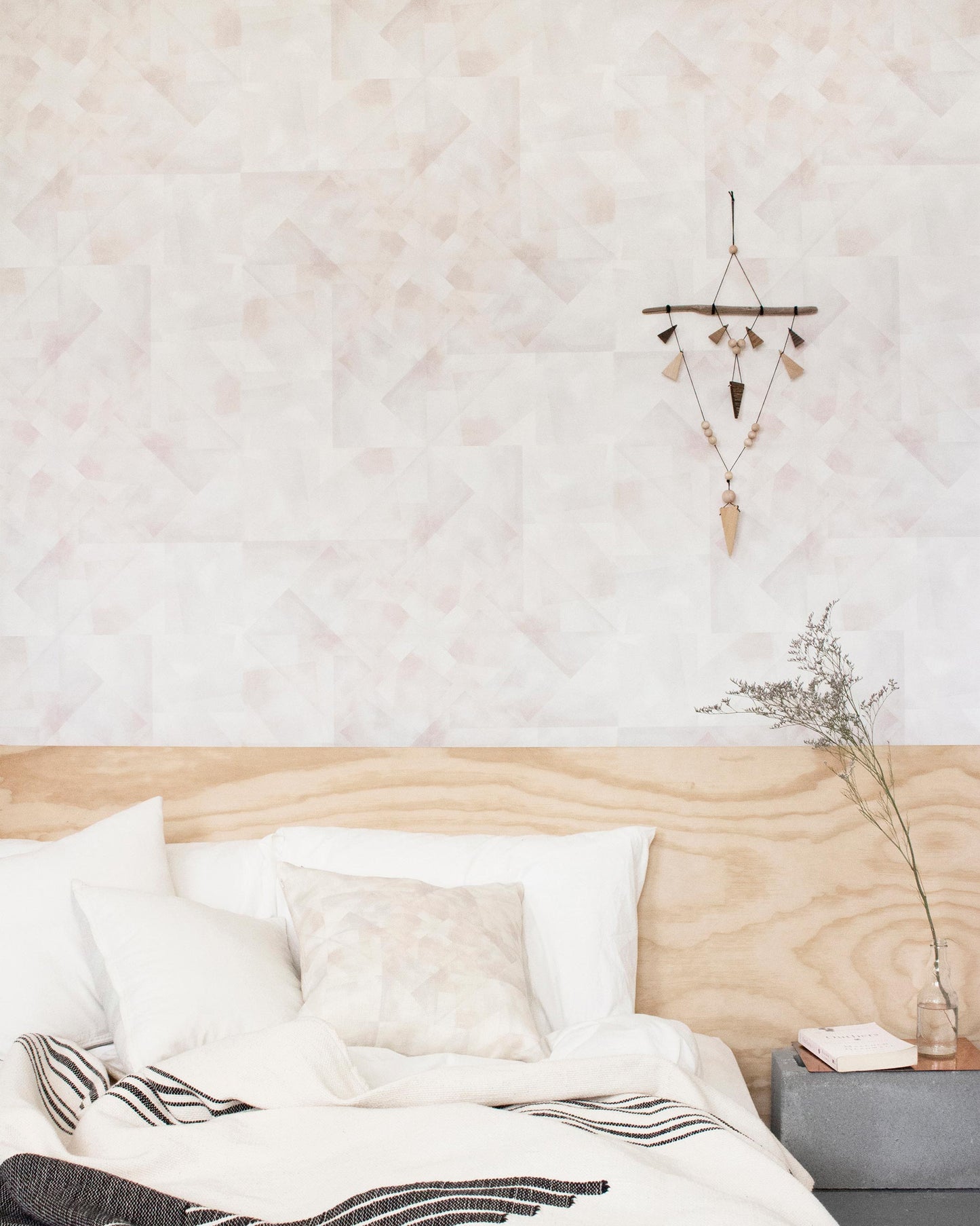 A bedroom with a white bed and a wooden headboard in the Canadian Pacific Northwest decorated with Kalos Wallpaper Cameo