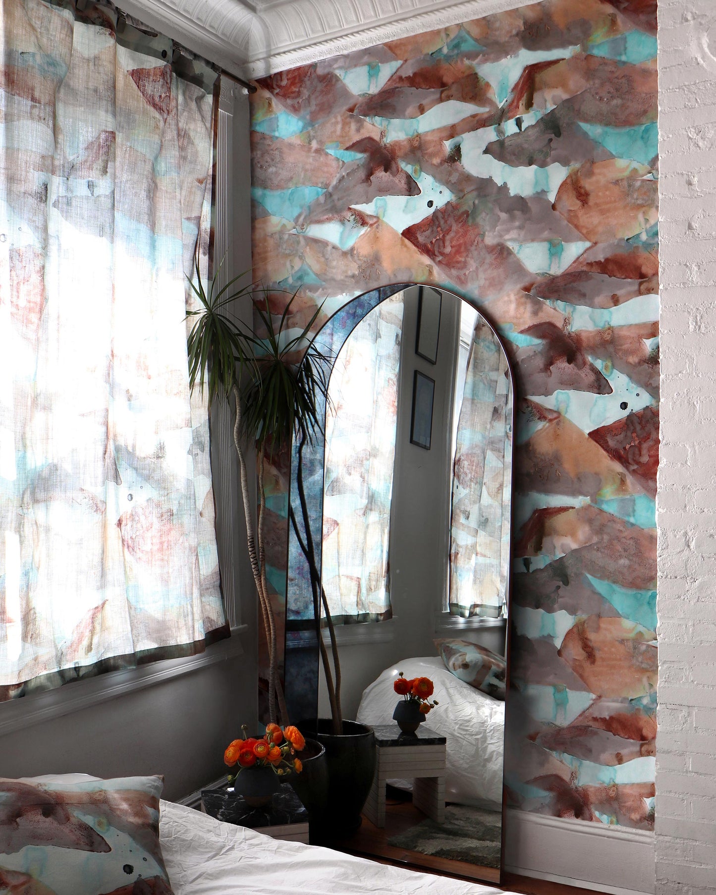 A bedroom with a Mani Wallpaper Morea and a mirror, inspired by the colorways of Greece