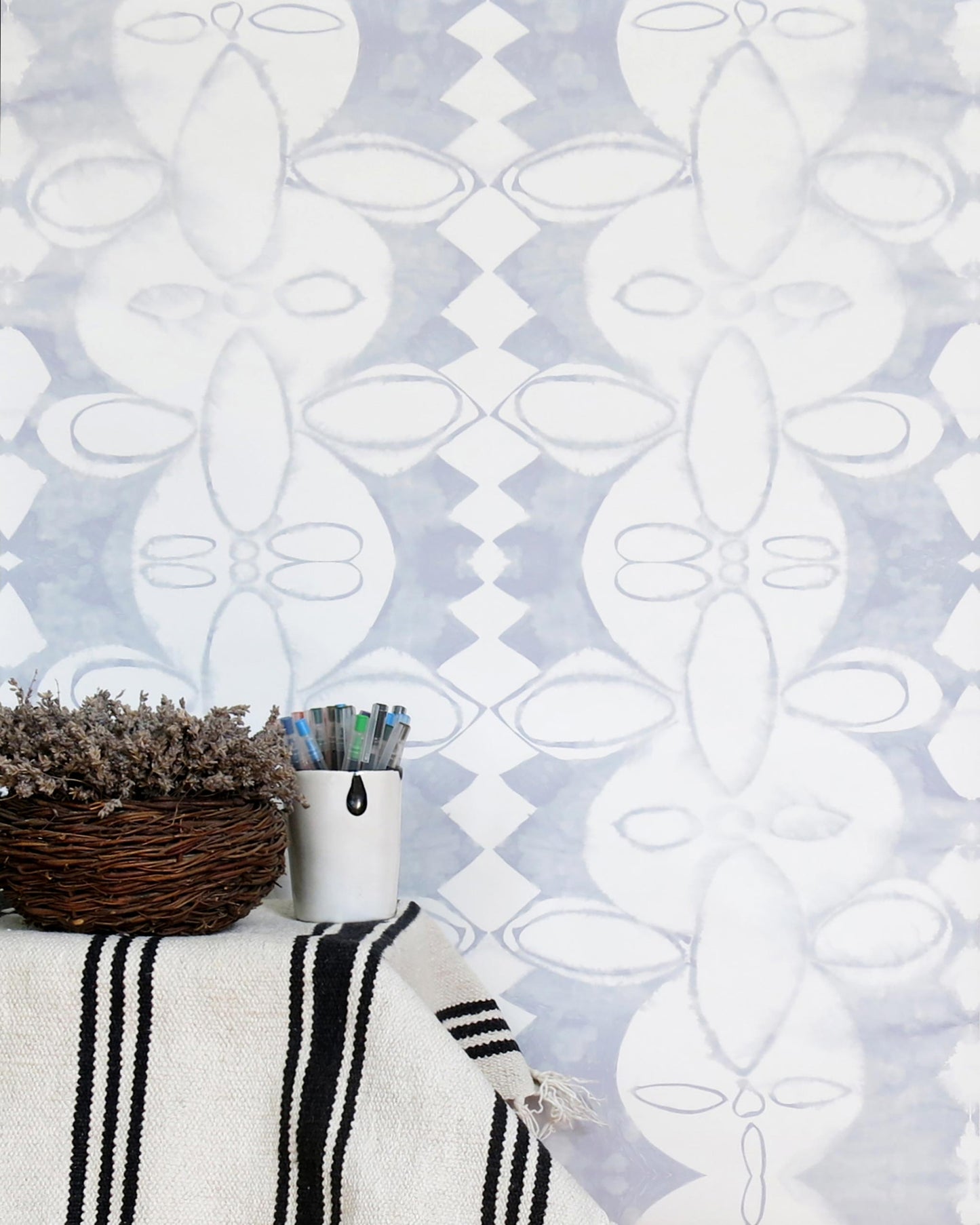 Coconut Chine Wallpaper Mist on a table next to a wicker basket