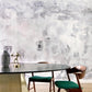 A dining room with a Kotoubia Wallpaper Mural Blanca tablecloth and elegant chairs in front of a wall