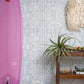 A pink Banda Wallpaper Cay leaning against a wall blended with high-end fabric and tie-dye techniques