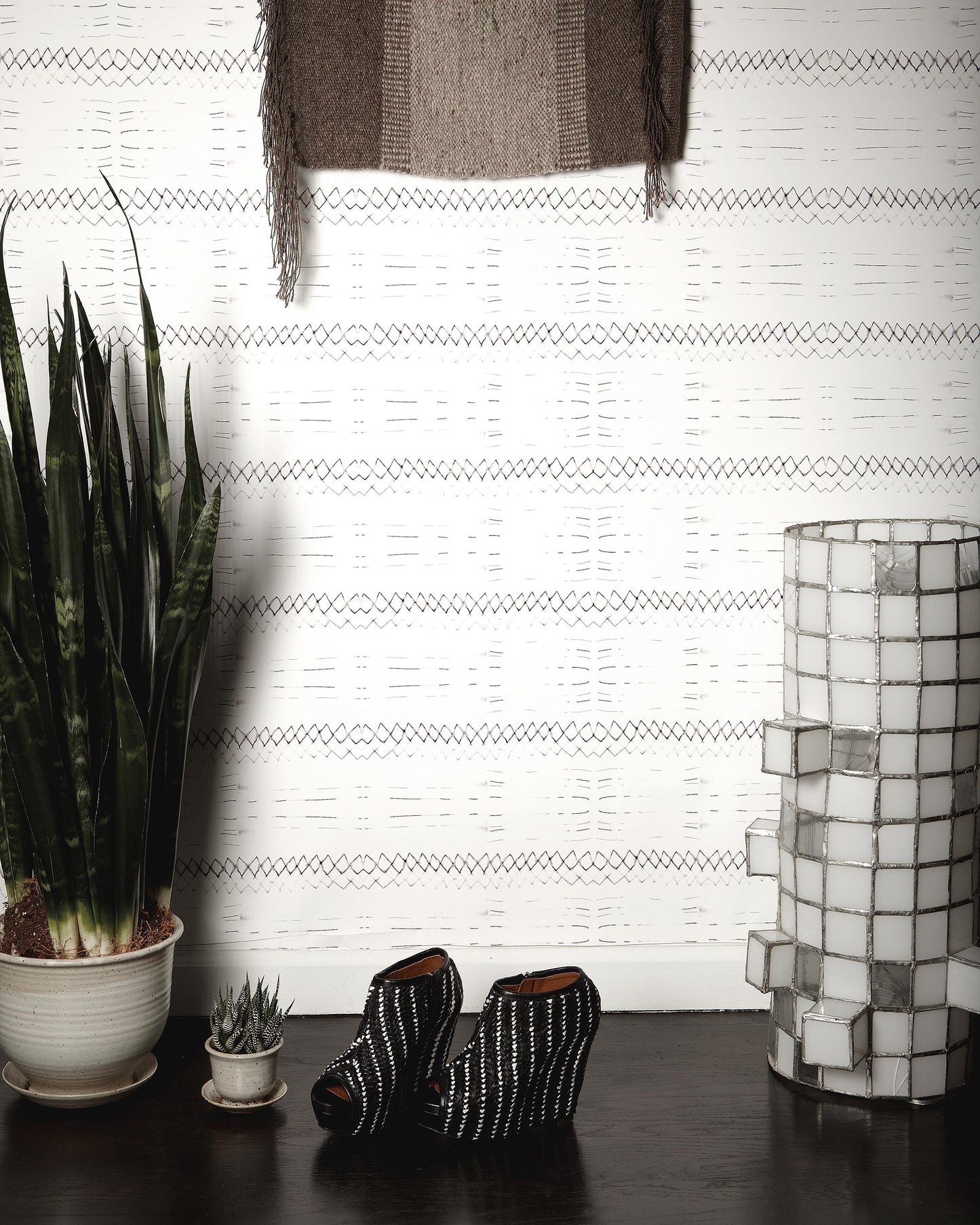A custom fabric with a graphic pattern, featuring a Native Stripe Wallpaper Black + White and a pair of shoes