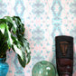 A vase with a plant in the Hive Wallpaper Citron colorway on top of it