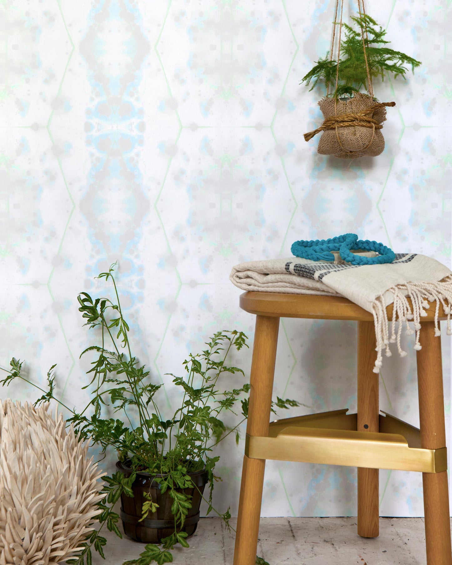 A stool with a potted plant in front of a Hive Wallpaper Nyanza