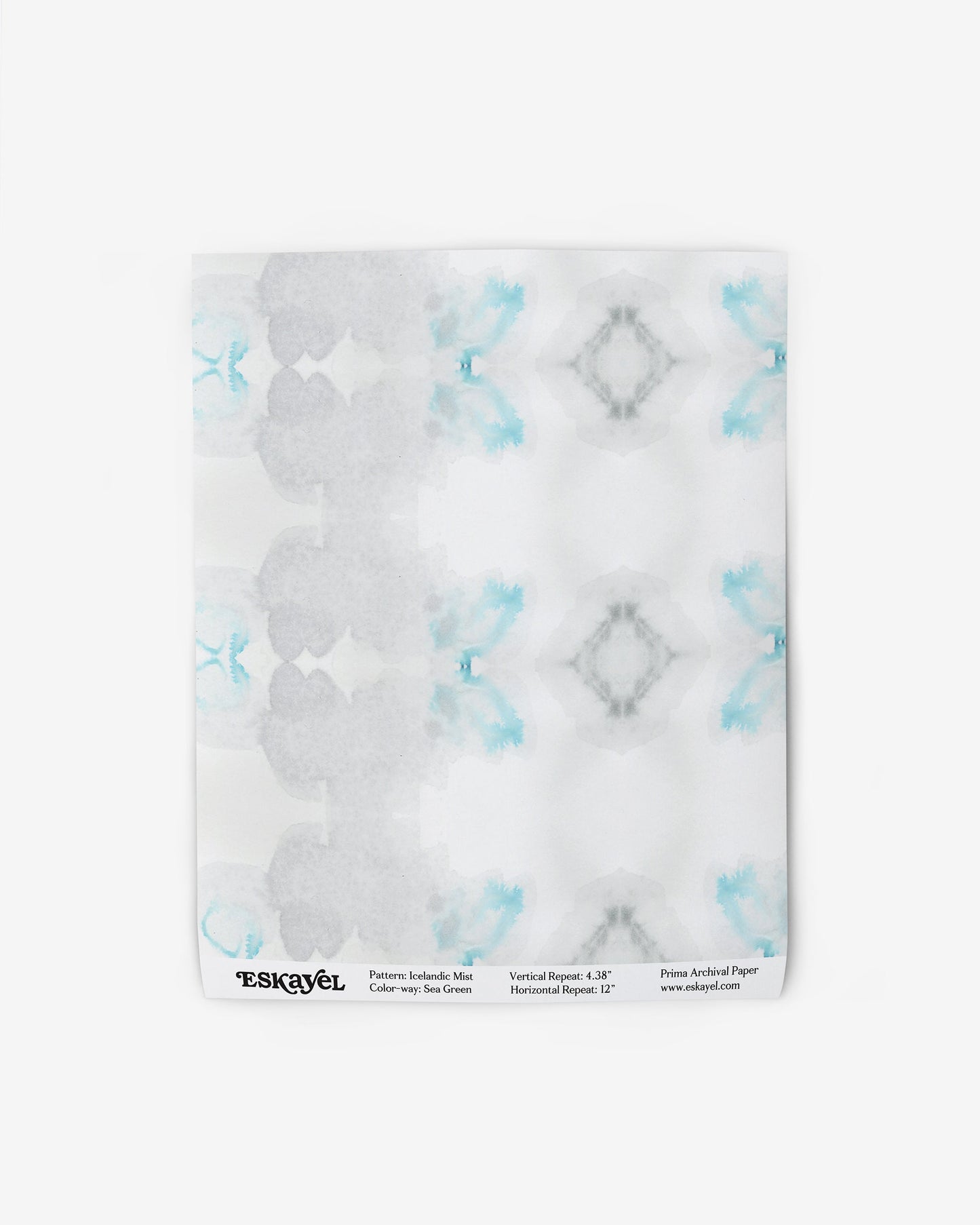 A blue and white design on a white plate decorated with Icelandic Mist Wallpaper in Sea Green