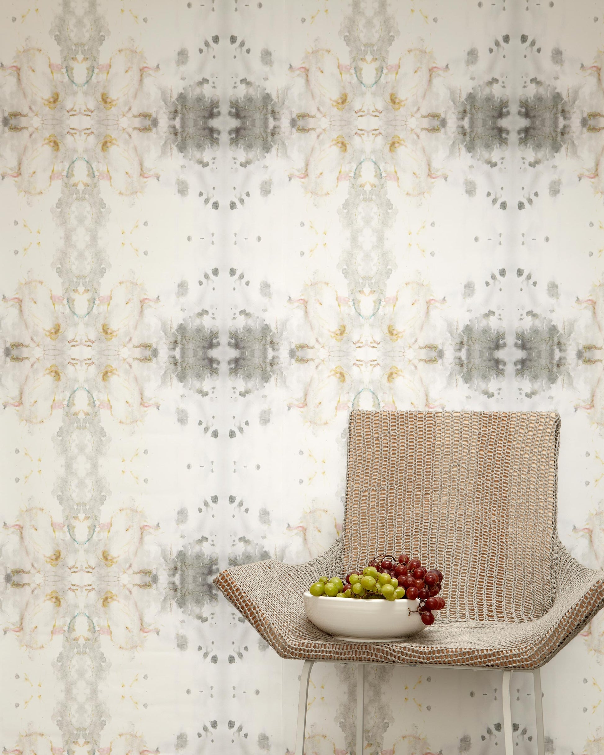 A chair with a bowl of grapes in front of a Roman Ram Wallpaper Light Metal