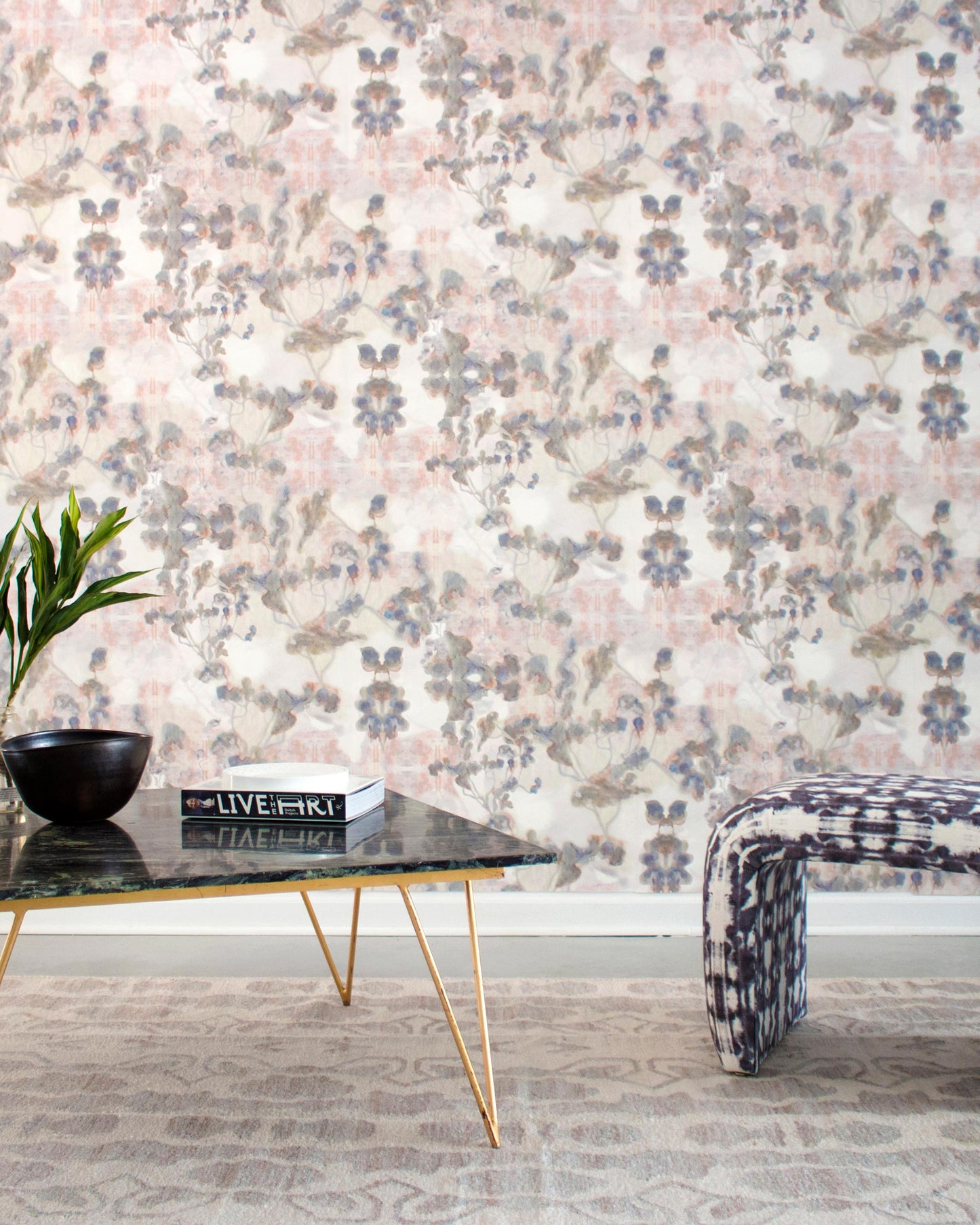 A living room with a floral Clemente Wallpaper Sol and a coffee table