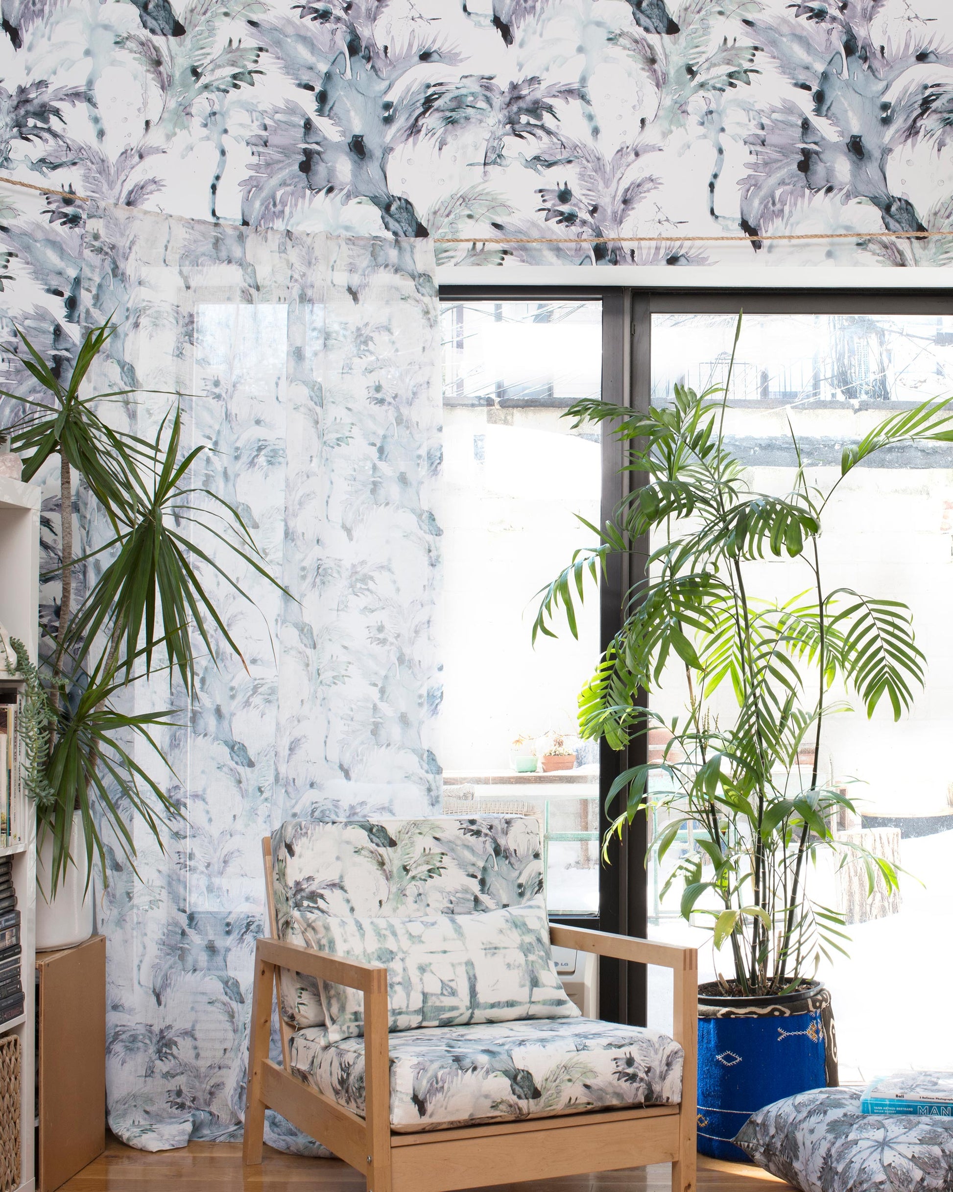 A living room with a large window and Cocos Wallpaper Chloros