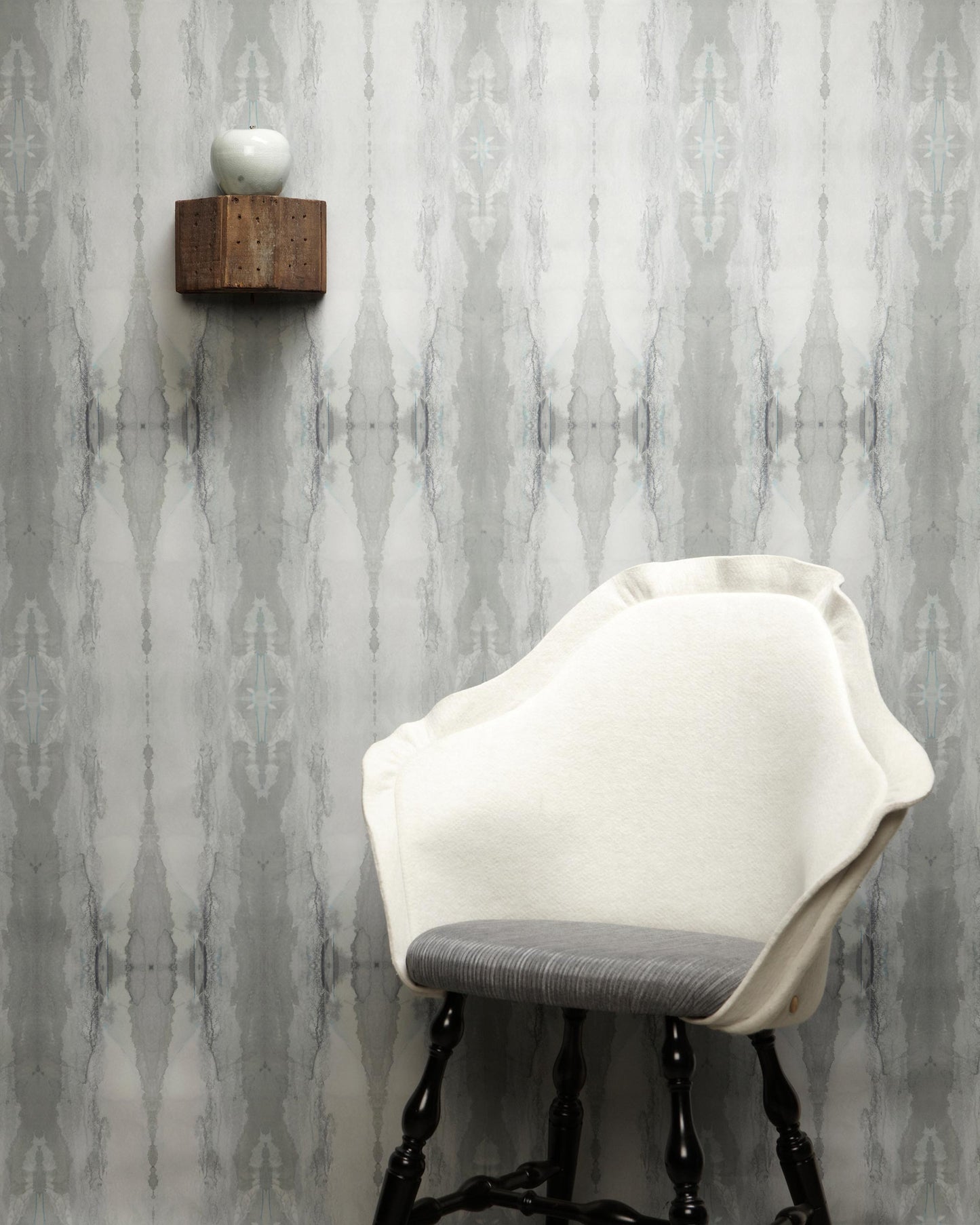 A white chair in front of a gray Feudal Facet Wallpaper Slate