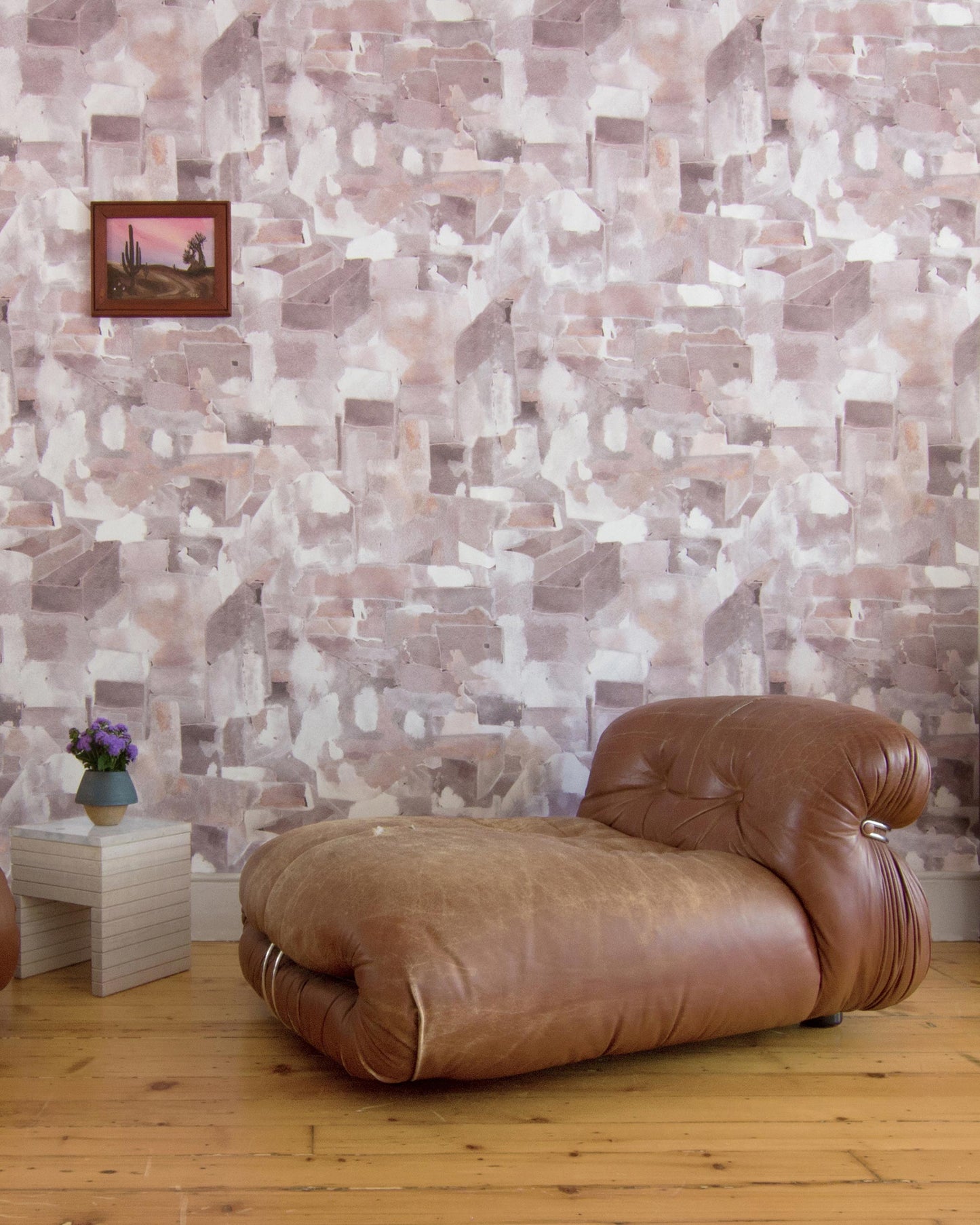 A living room with brown leather chairs and a Medina Wallpaper Pausa