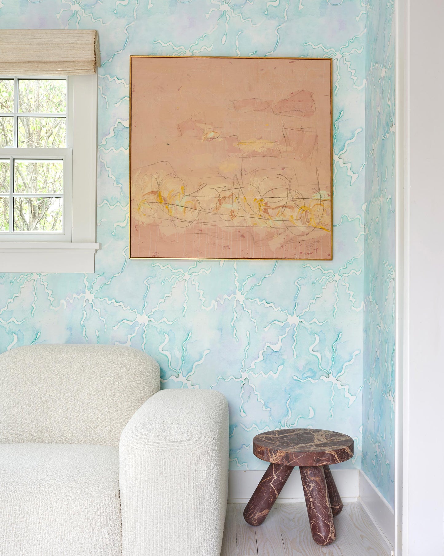 A living room with blue Pecosa Wallpaper Brisa wallpaper and a white couch