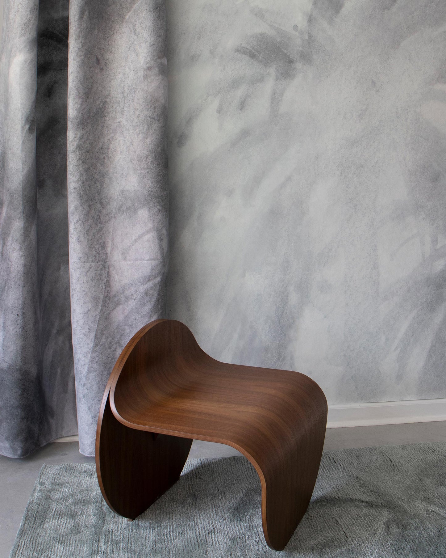 A Reflettere Wallpaper Mural Aqua stool in front of a wall