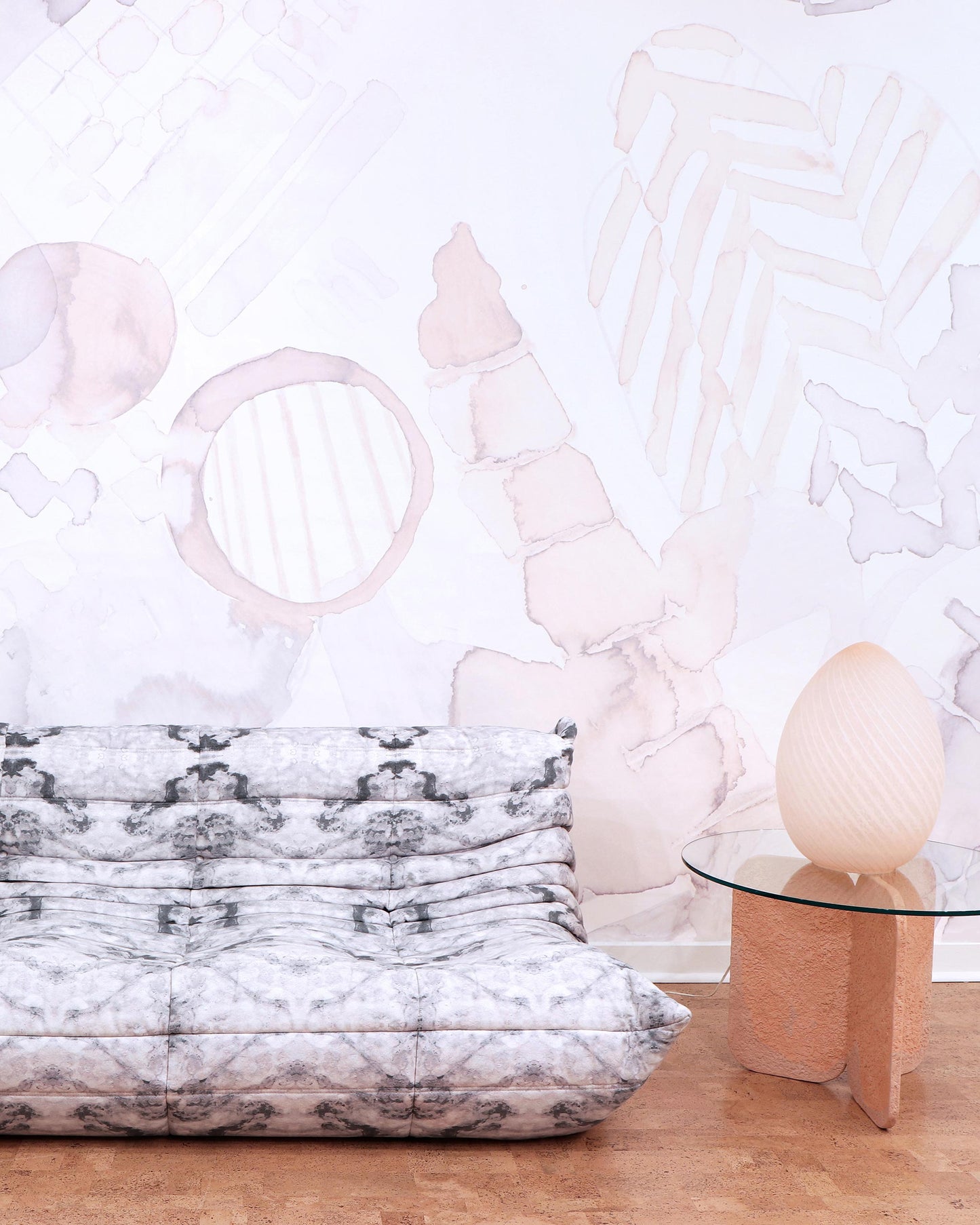 A white couch is sitting in front of a white wall with the Sea Galaxy Wallpaper Coral mural artwork