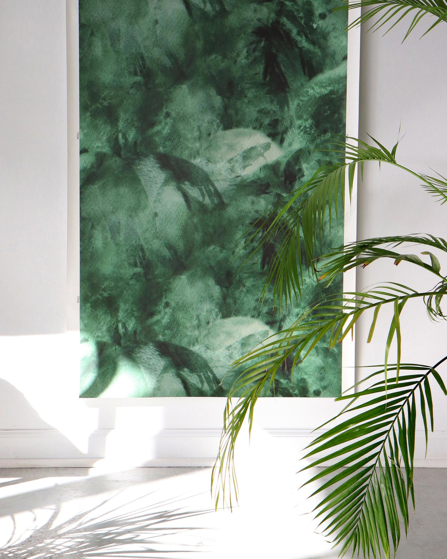 A picture of a Palmeti Wallpaper Verde in front of a white wall with green tones