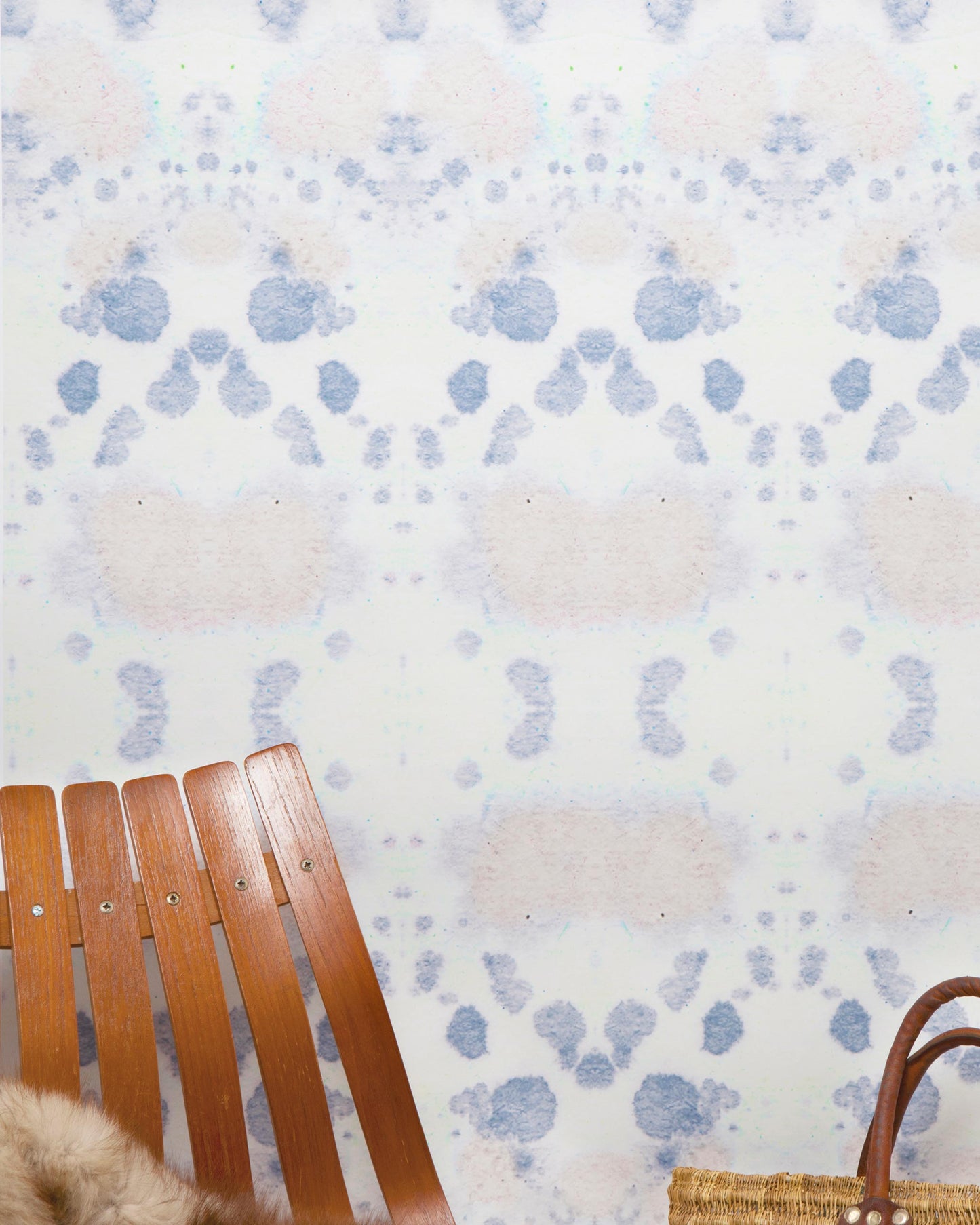A wicker chair sits in front of a blue and white Species Wallpaper ink kaleidoscopic effect