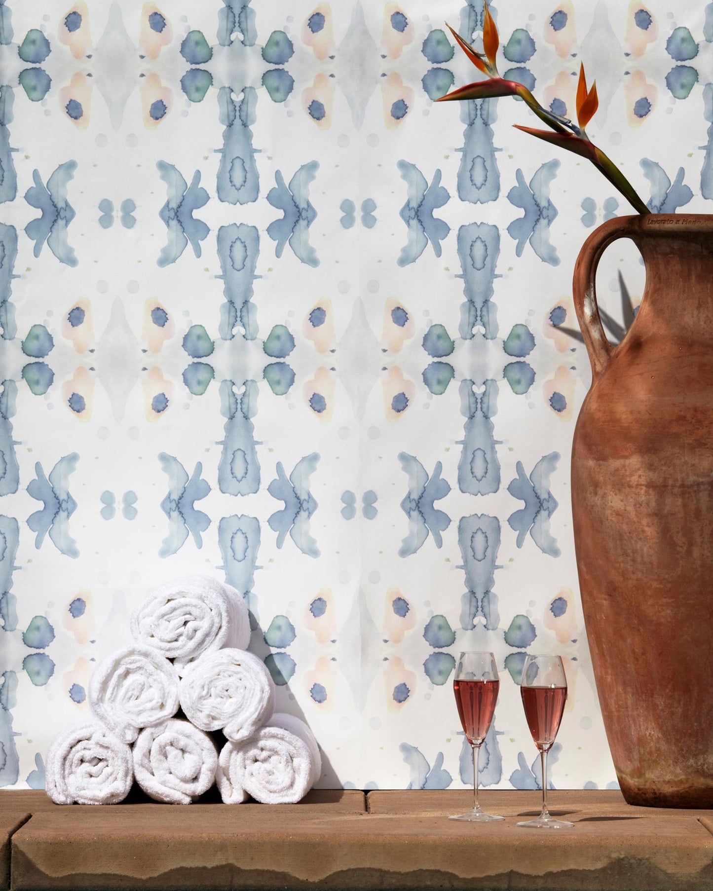 A vase of Splash Wallpaper Cerulean and a vase of flowers on a table at Le Petit Ermitage