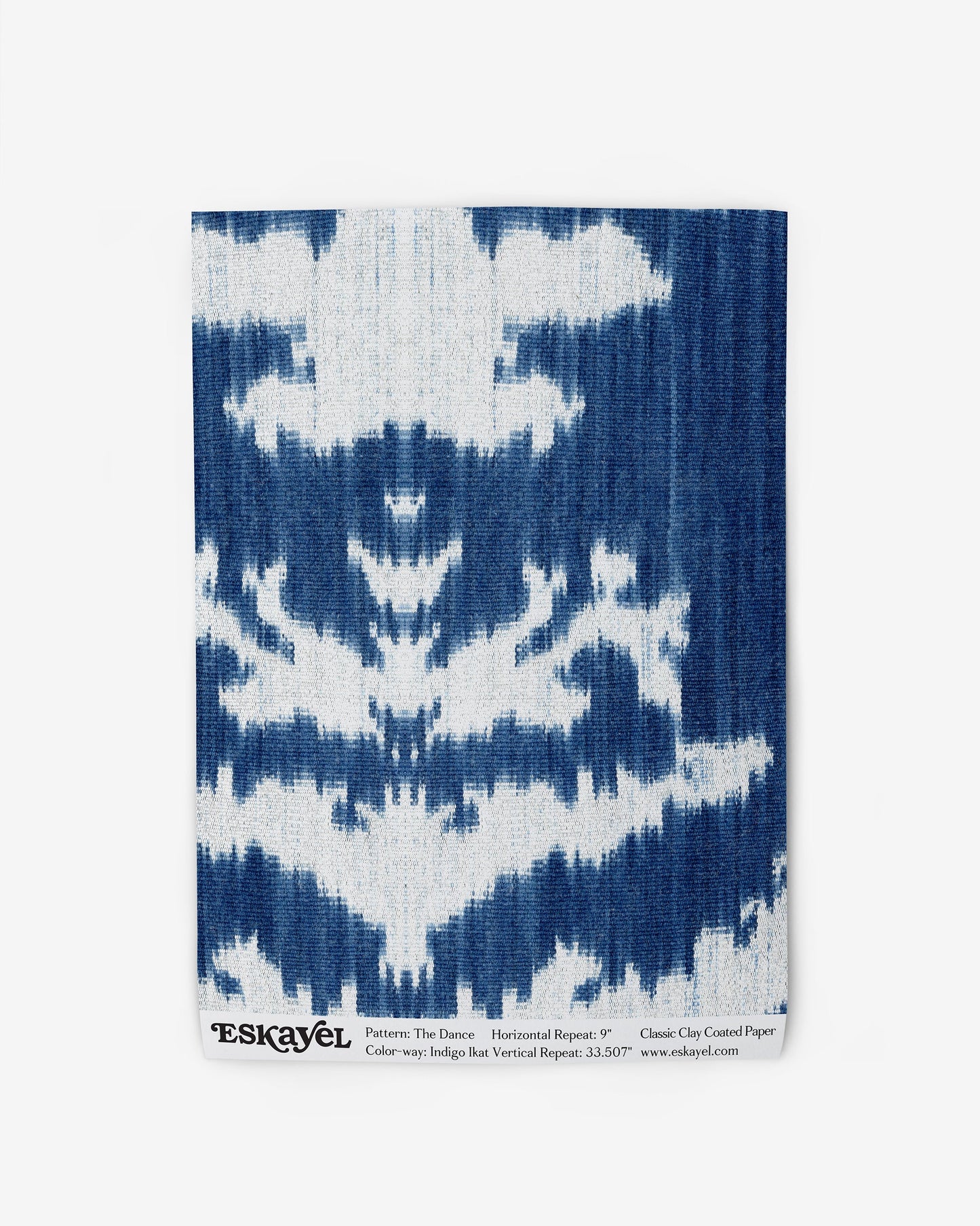 A blue and white fabric with The Dance Wallpaper Indigo Ikat design on it