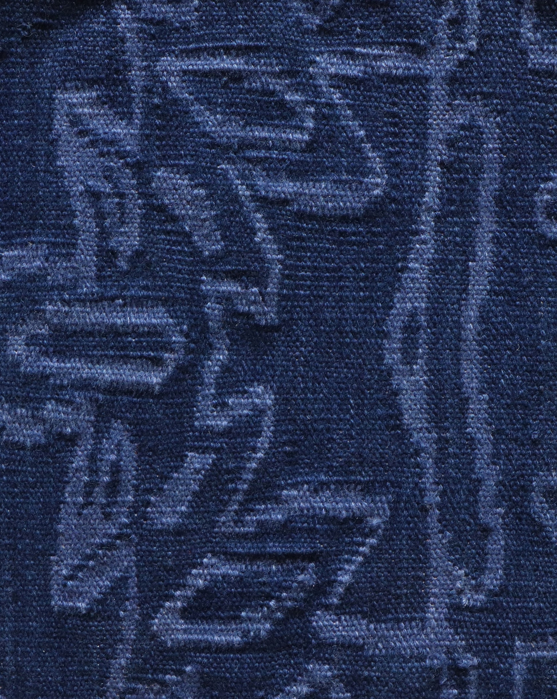 A close up of an Akimbo 5 Flatweave Rug Indigo with a graphic geometric pattern on it