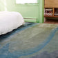 A green bedroom with a luxurious Progressions Hand Knotted Rug made of chromatic beauty and made from merino wool