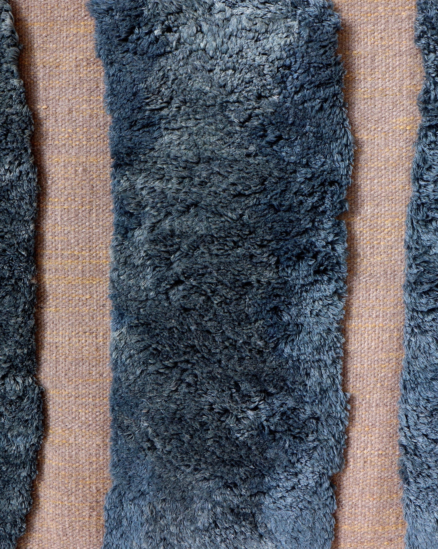 A group of Bold Stripe Hand Knotted Rugs Thalassa, incorporating hybrid weaving techniques, on a table