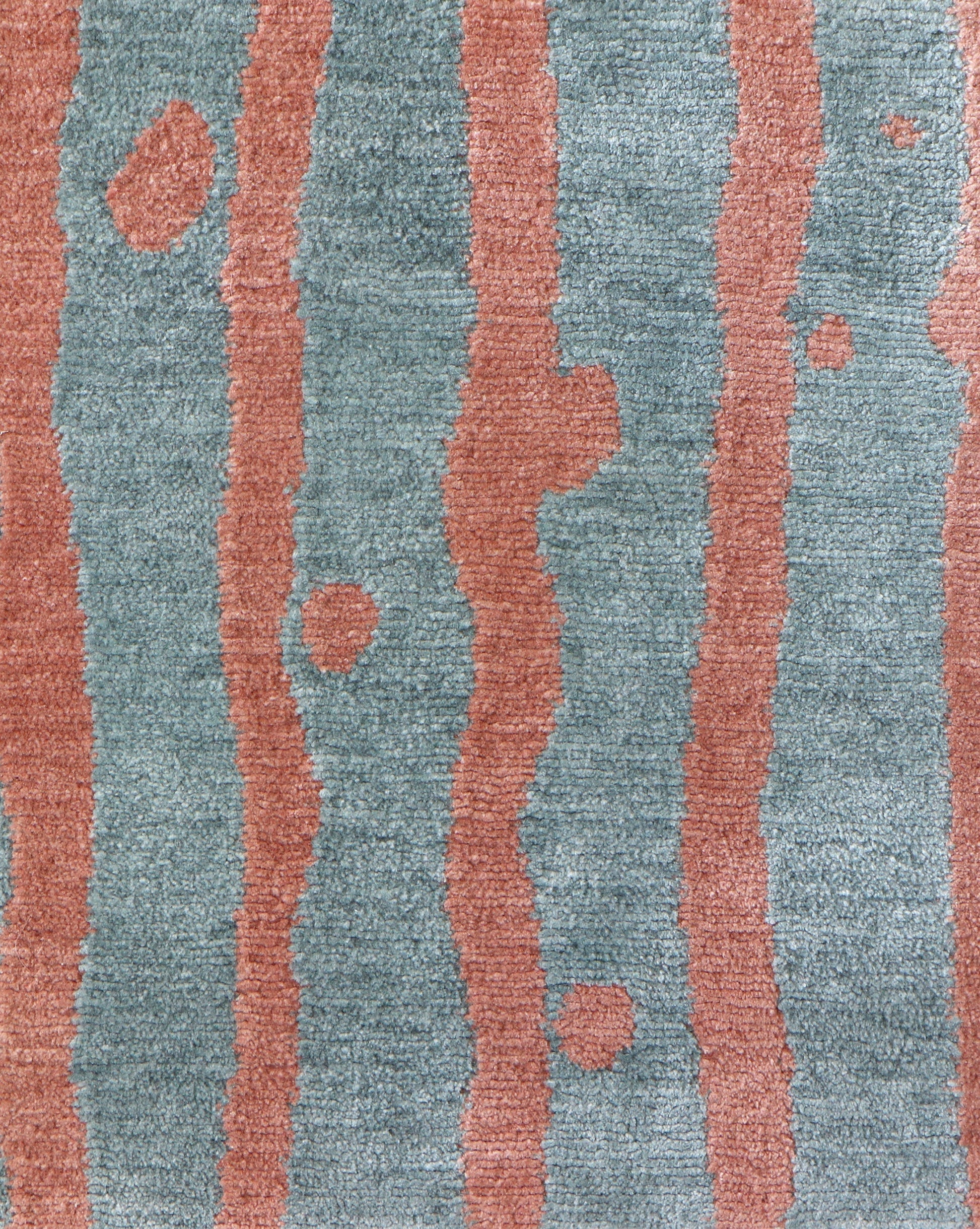A bold Drippy Stripe Hand Knotted Rug with blue and pink stripes created using hybrid weaving techniques