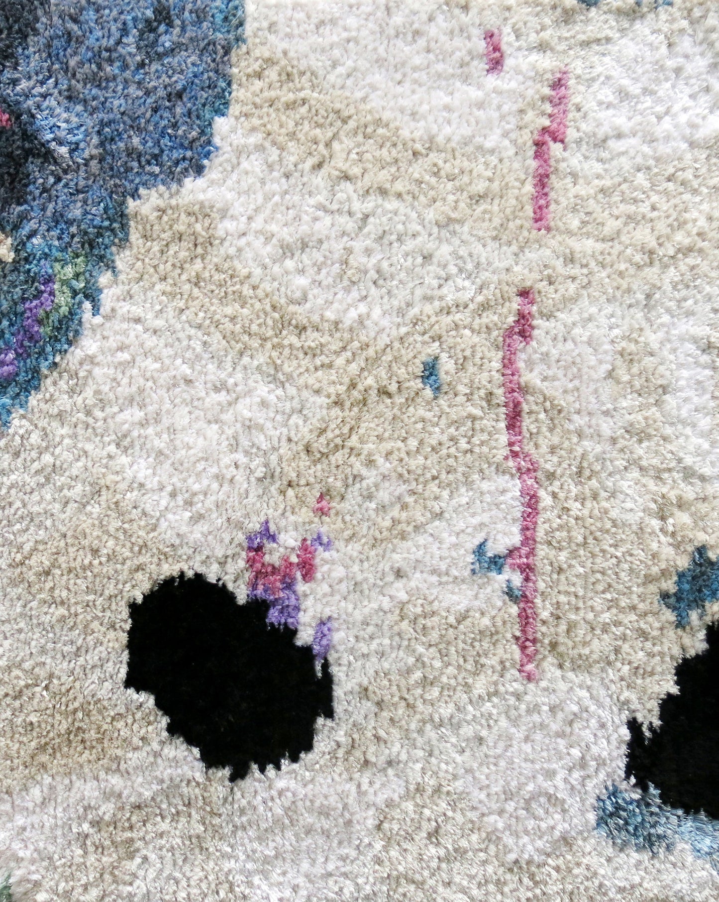 A close up of a Galileo Glass Hand Knotted Rug Slate with holes in it