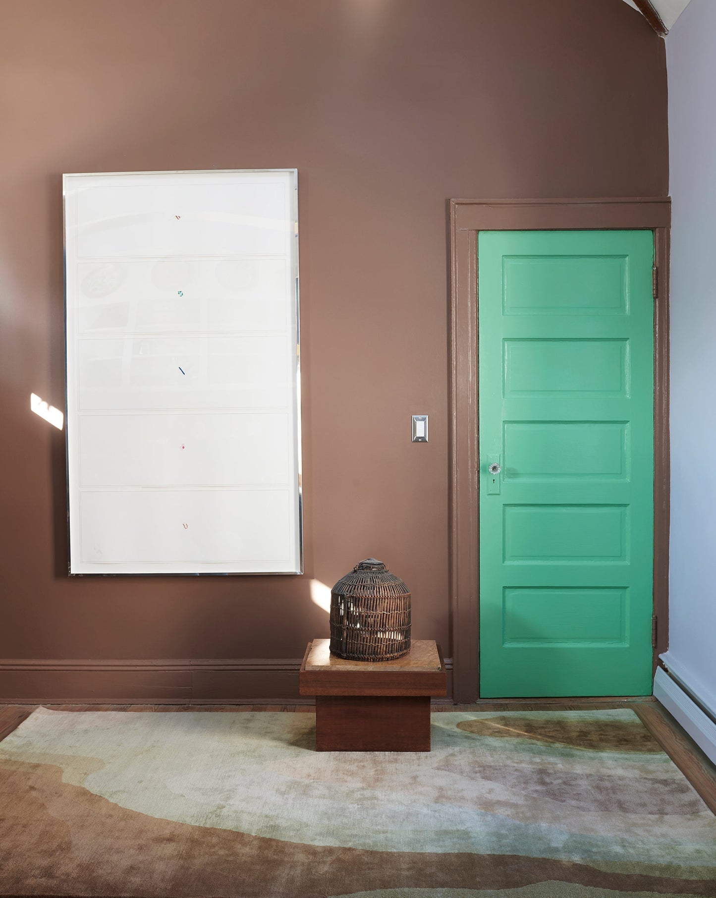 A room with a green door and a Progressions Hand Knotted Rug Corinth