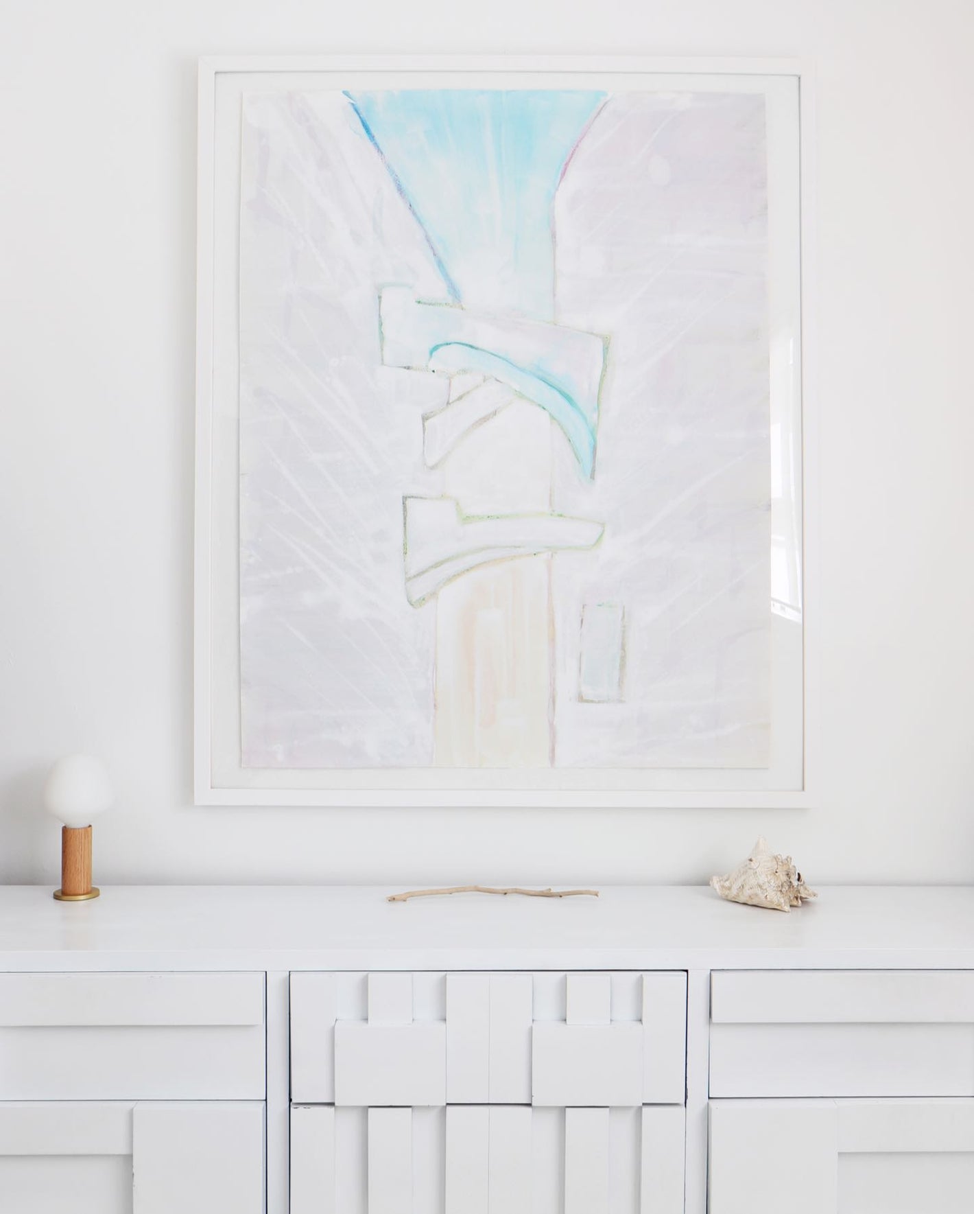 A white dresser with a painting