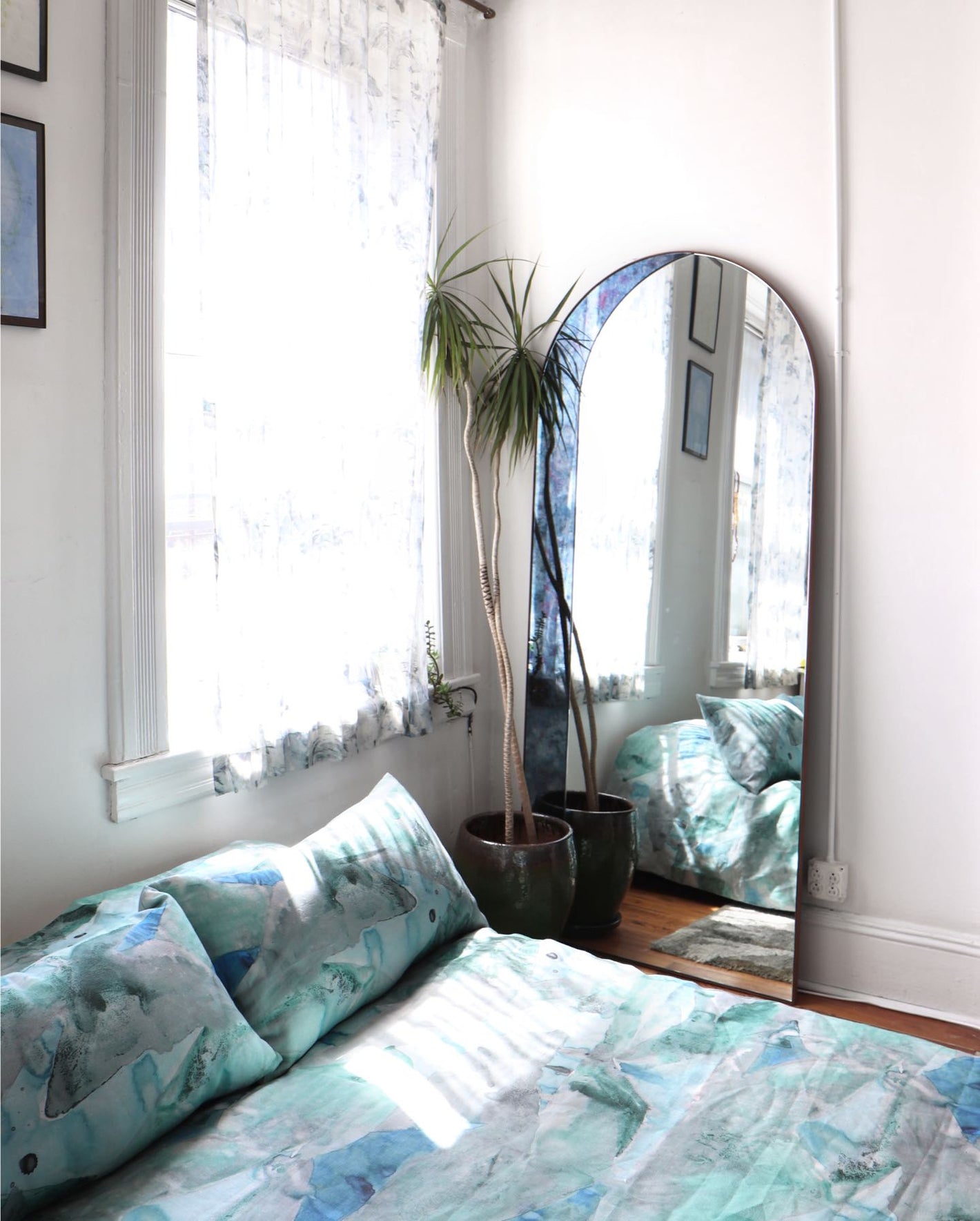 A bedroom with a bed and a mirror