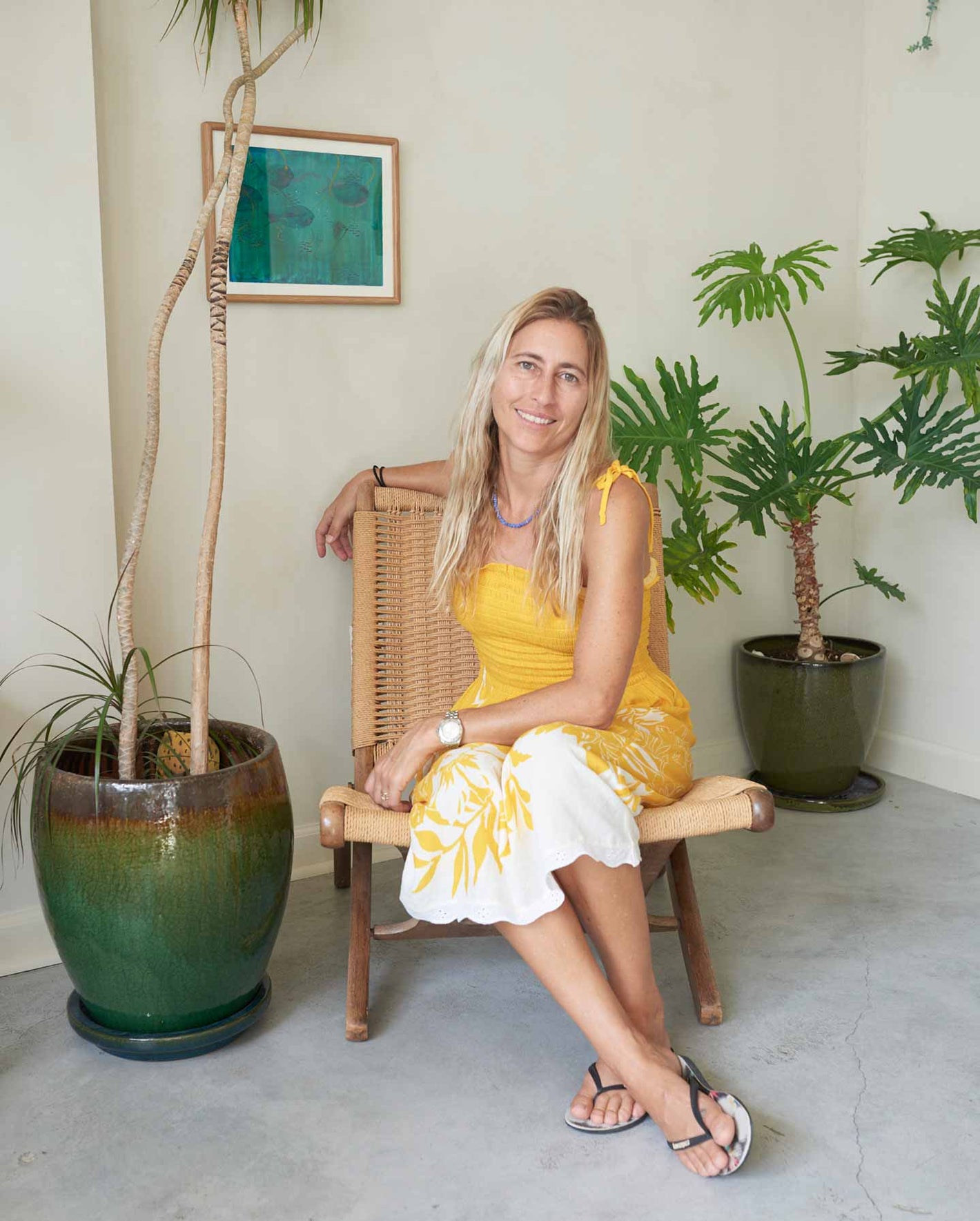 A woman wearing a yellow dress and sitting in a chair. 