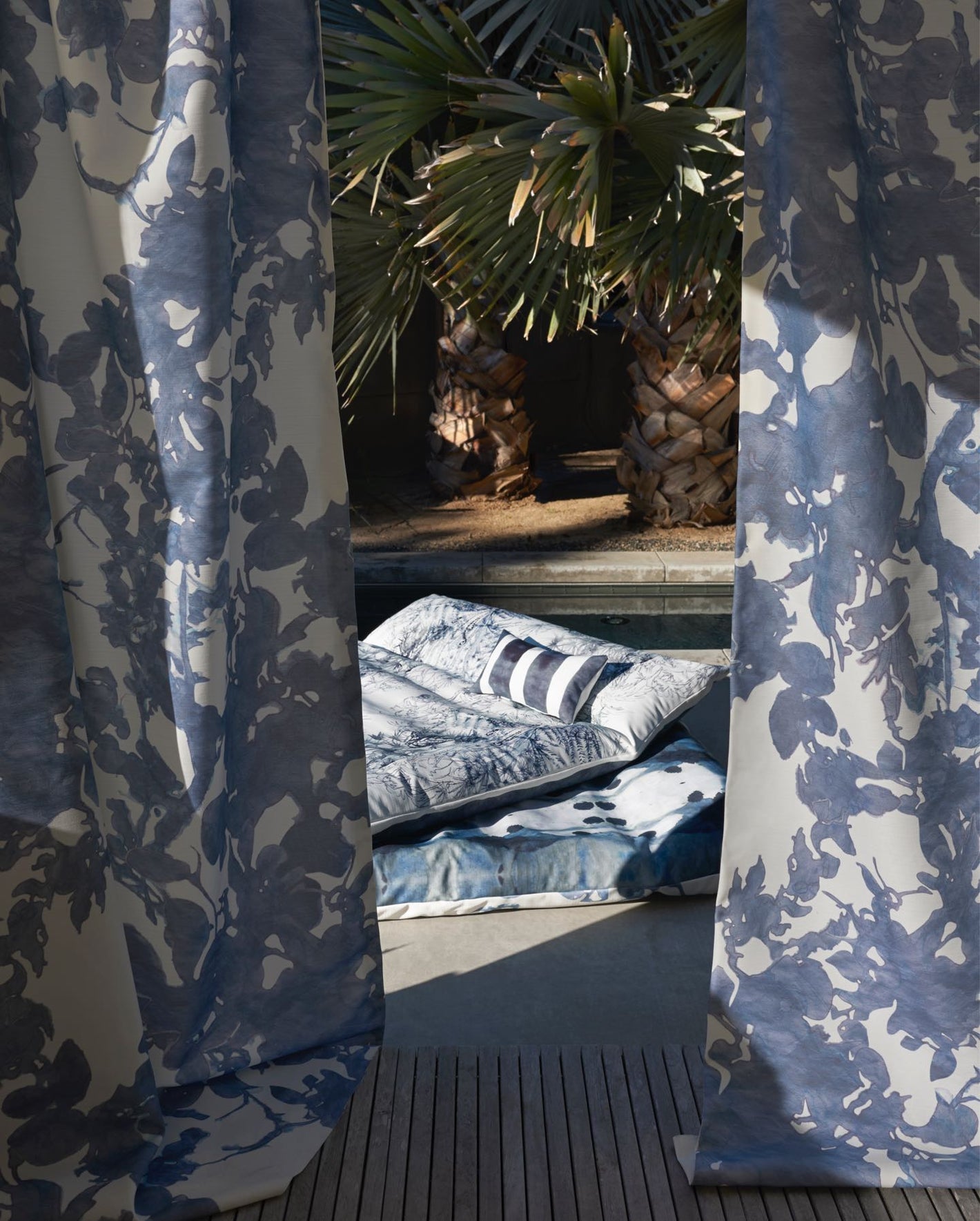 A blue and white curtain with a palm tree in the background